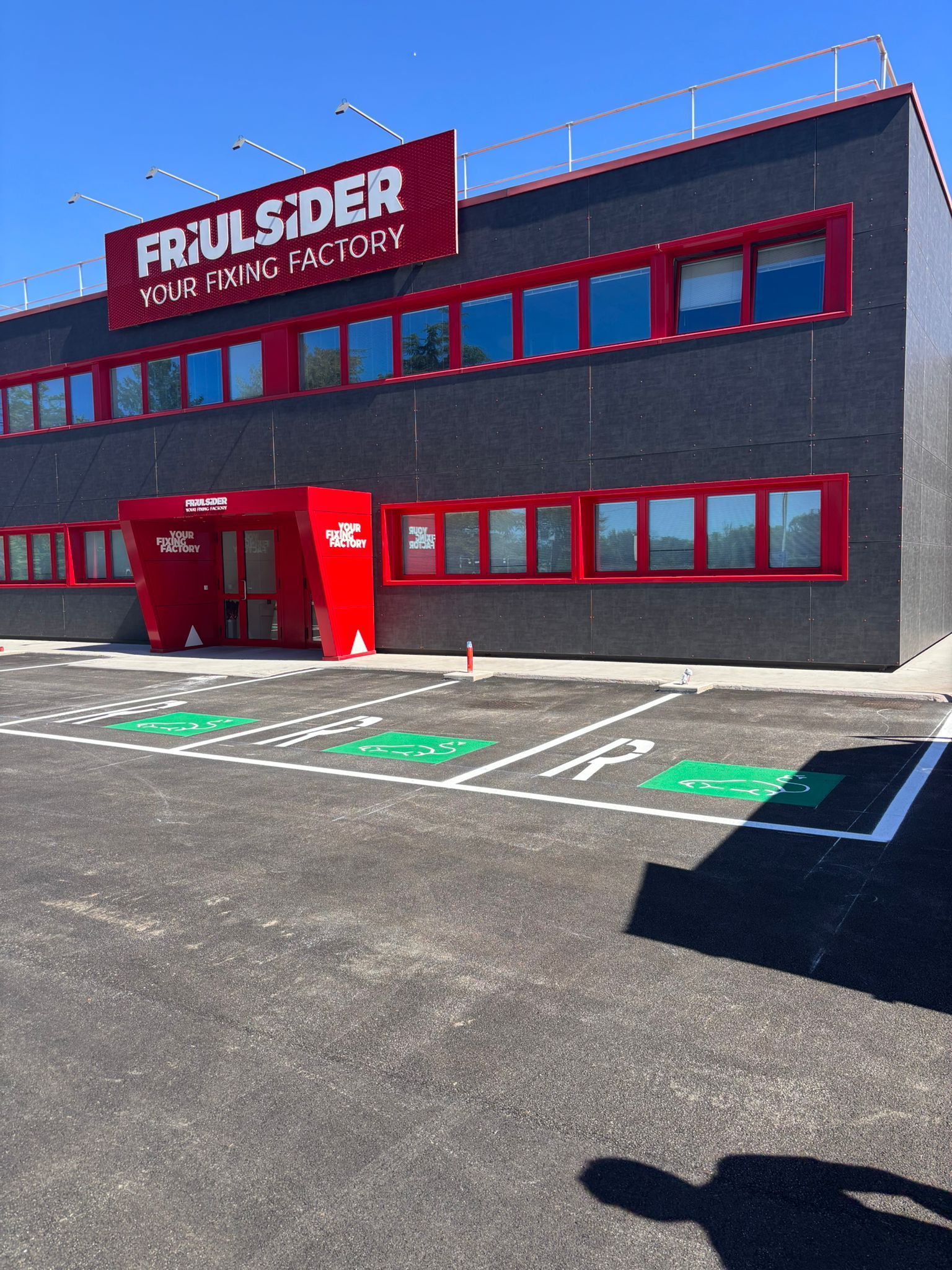 Edificio moderno, grigio con accenti rossi, insegna 