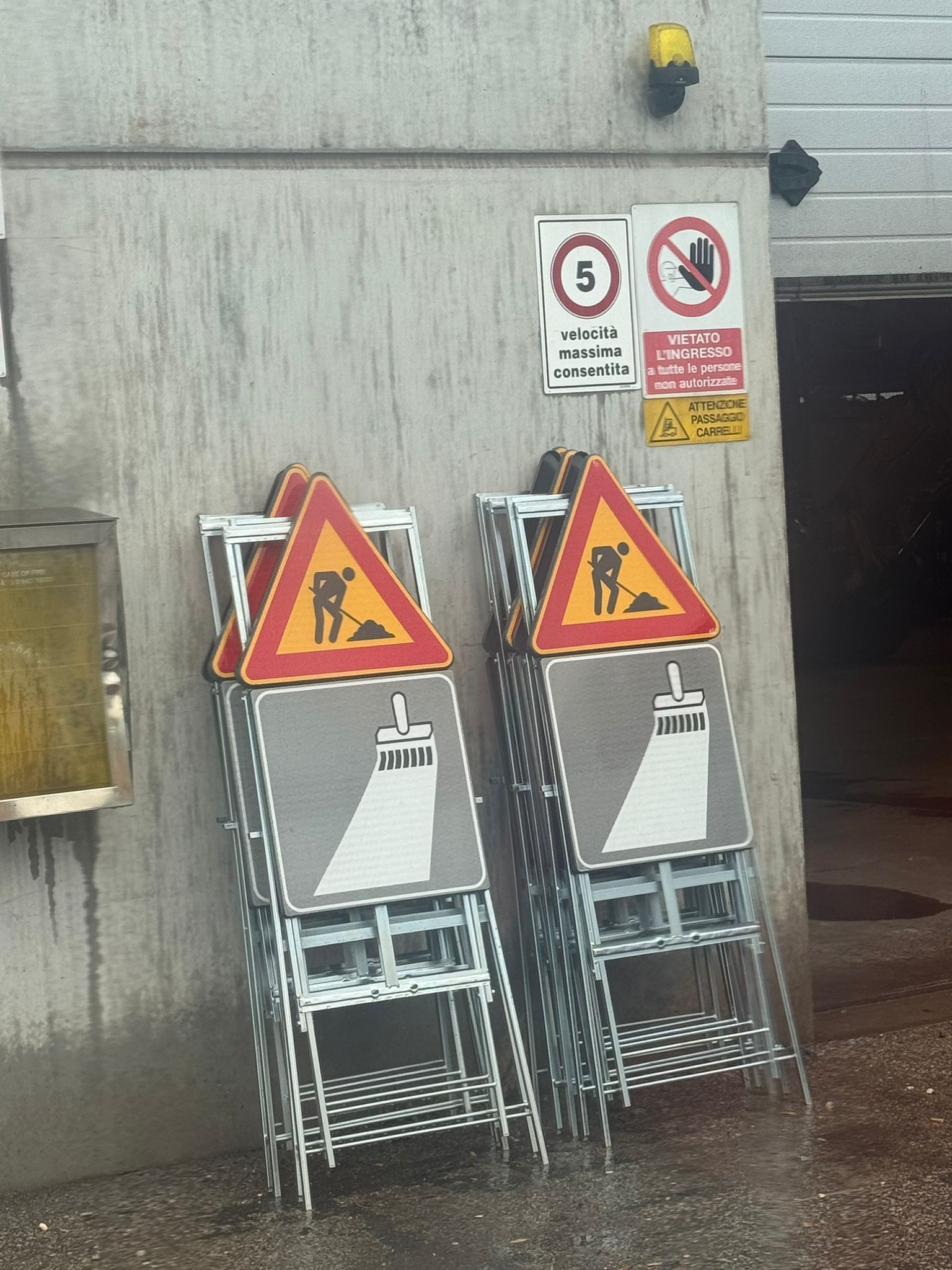 Attraversamento pedonale con strisce gialle e bianche, delimitato da coni, in una strada stretta con un grosso camion.