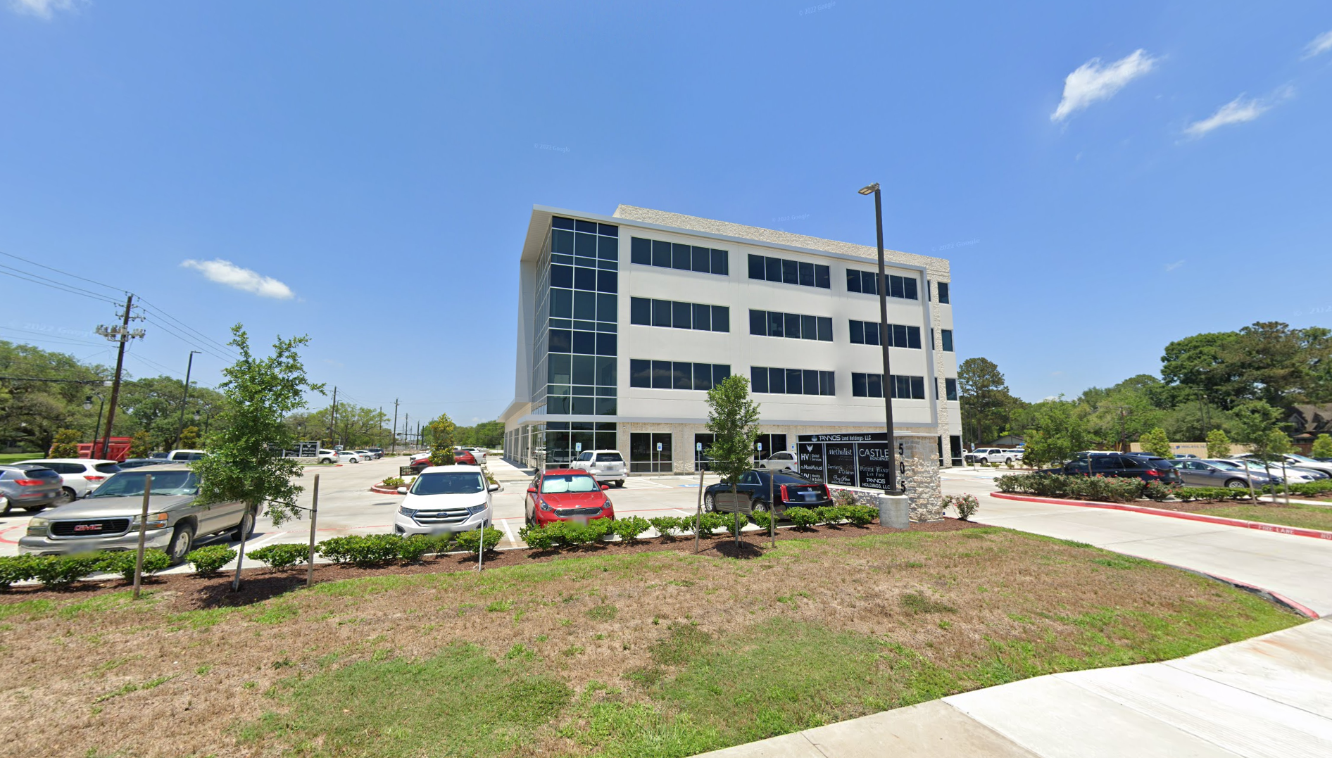 A large building with a lot of cars parked in front of it.on