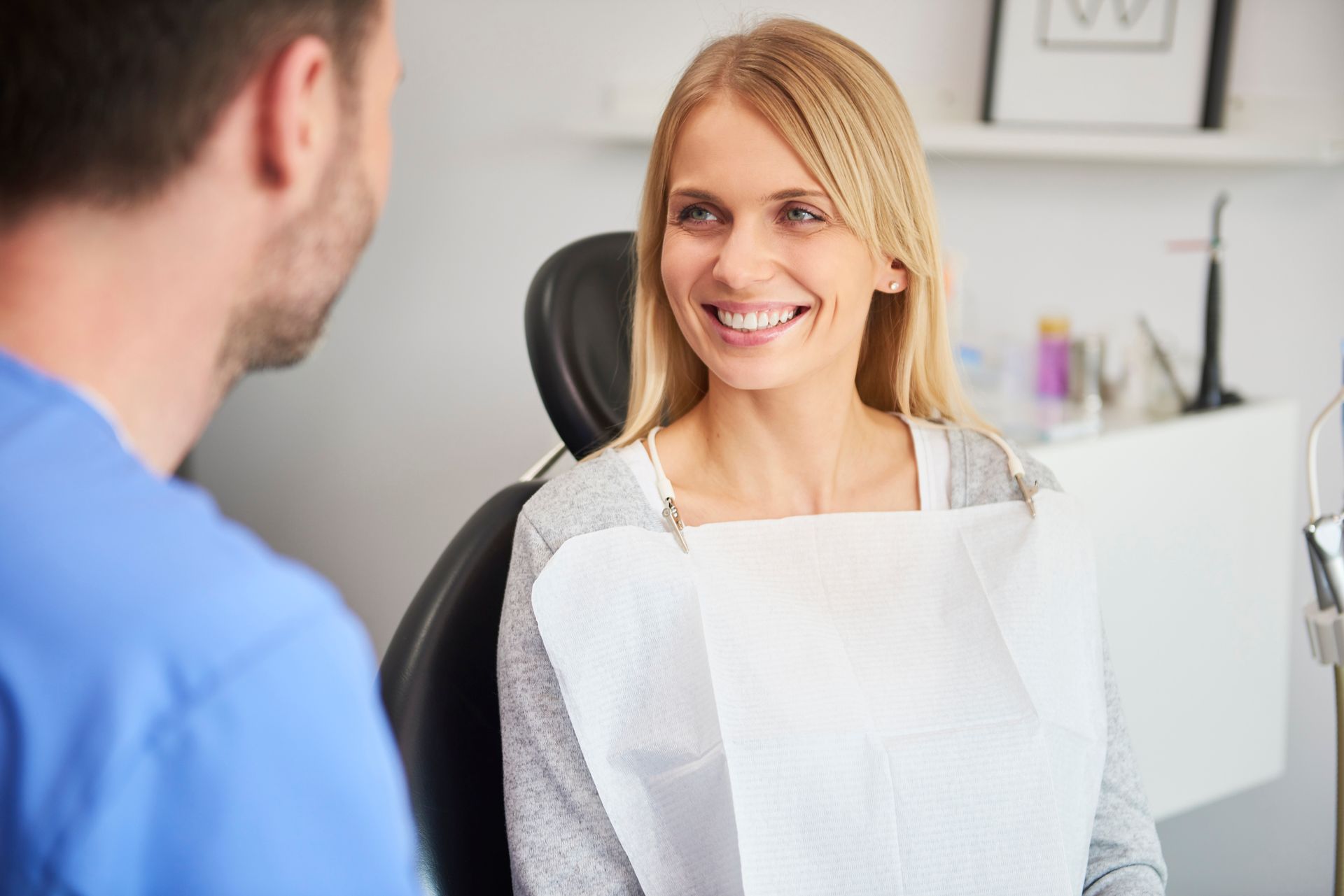 A model of a person 's teeth is sitting on a blue table next to dental instruments.