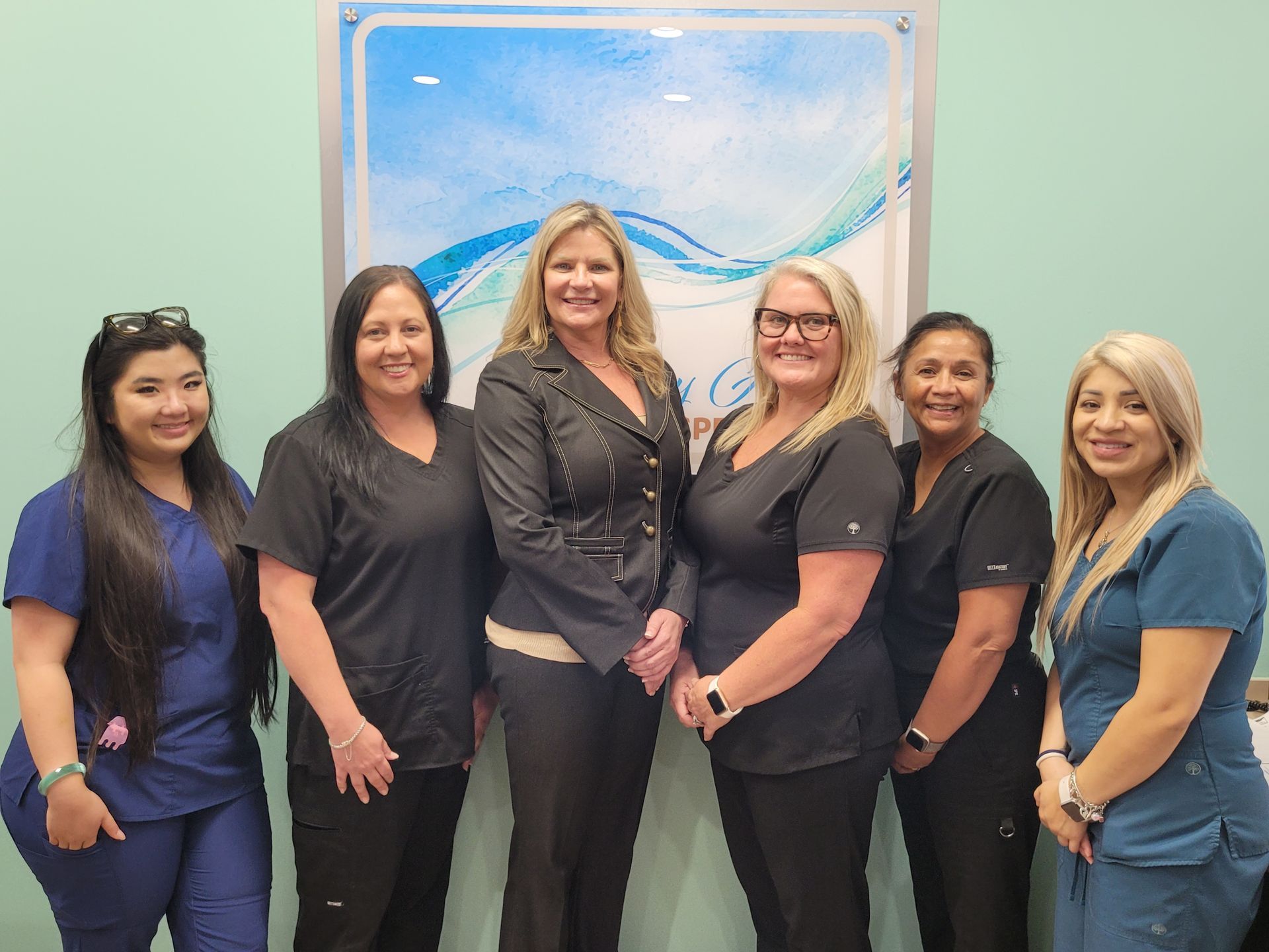 A group of women in scrubs are posing for a picture.