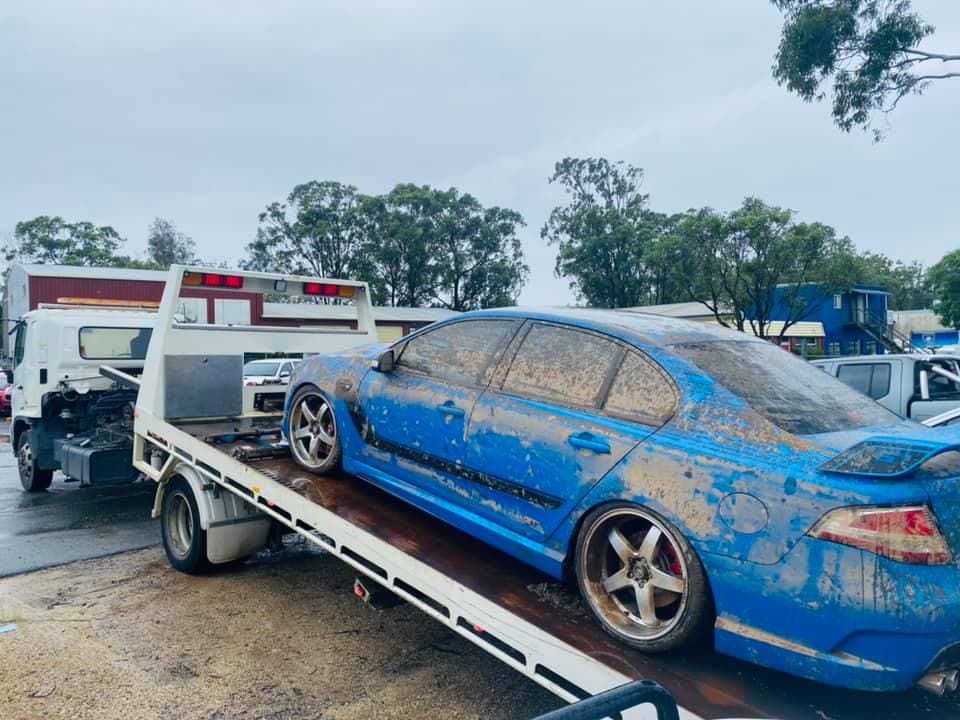 Muddy Blue Vehicle on a Tow Truck — Port Macquarie Tilt Tray Towing in Telegraph Point, NSW