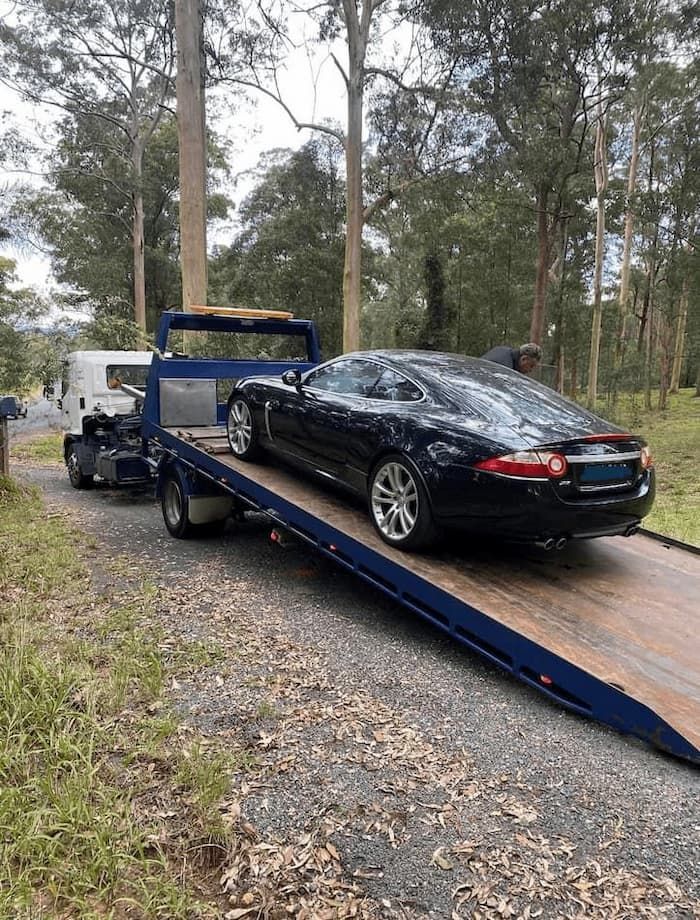 Tow Truck Assisting a Stranded Car in the Forest — Port Macquarie Tilt Tray Towing in Telegraph Point, NSW
