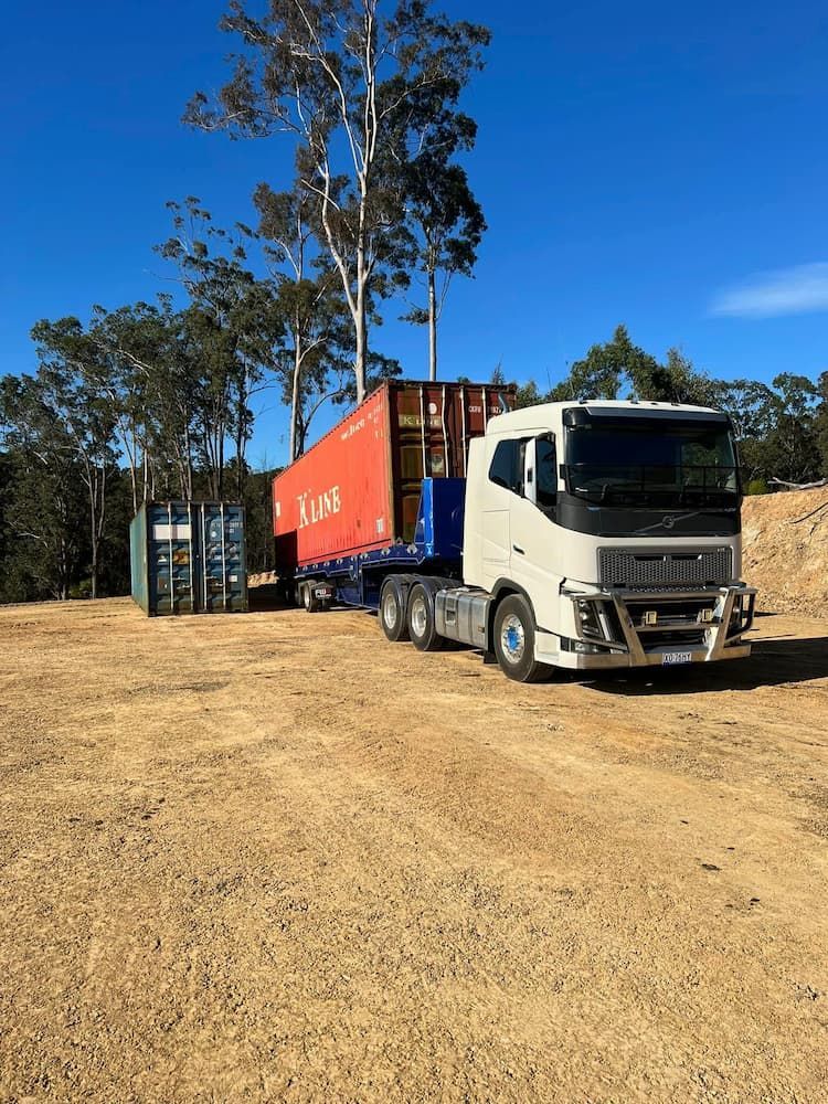 A White Truck Hauling Containers in a Yard — Port Macquarie Tilt Tray Towing in Telegraph Point, NSW