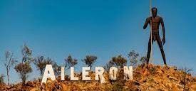 A statue of a man standing on top of a hill next to the word aileron.