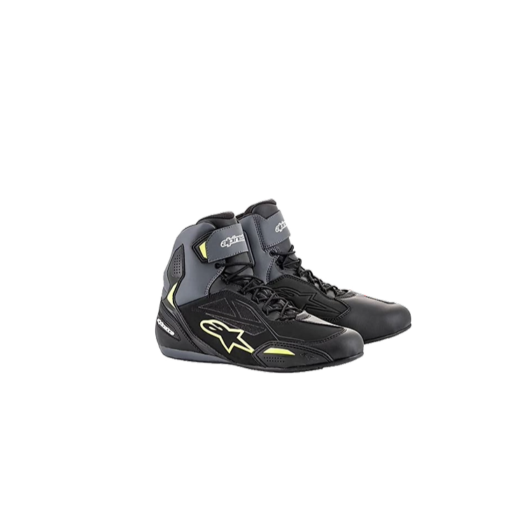 A pair of black and yellow motorcycle boots on a white background.