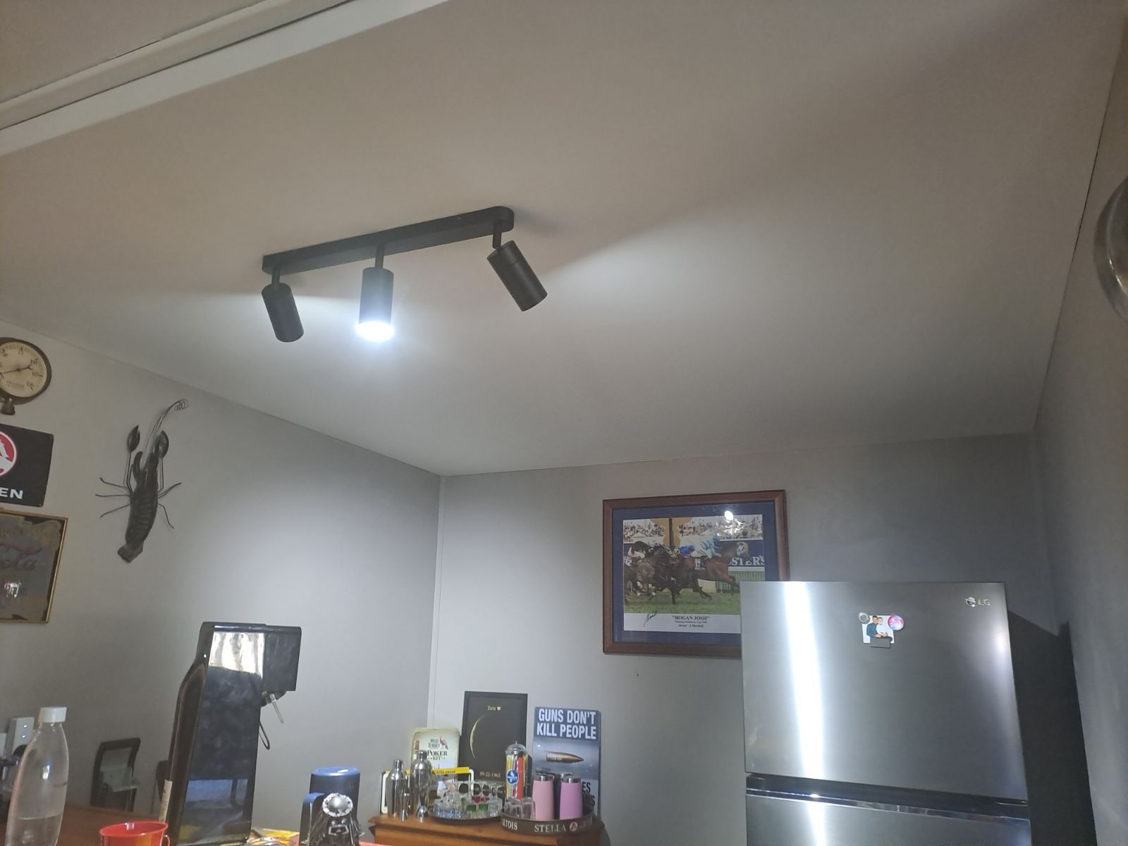 A kitchen with a stainless steel refrigerator and a picture on the wall.