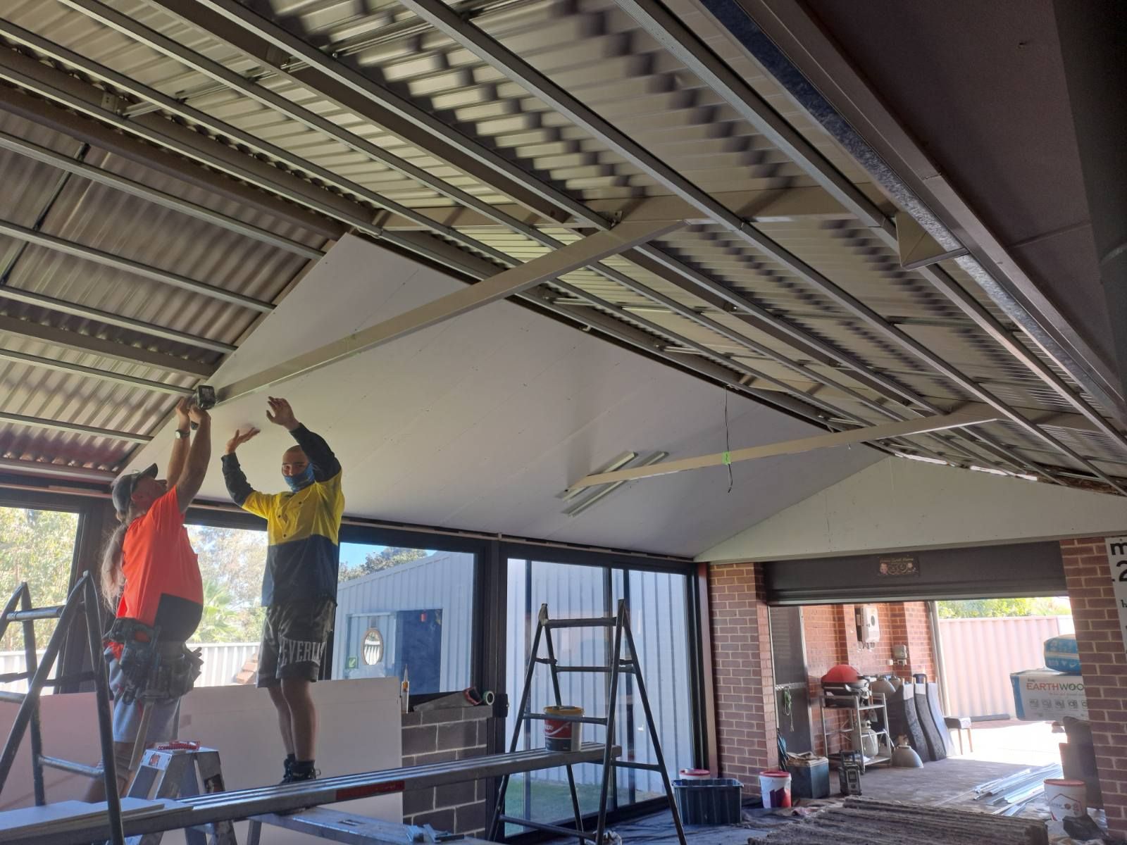 A white wall with a hole in it and peeling paint.