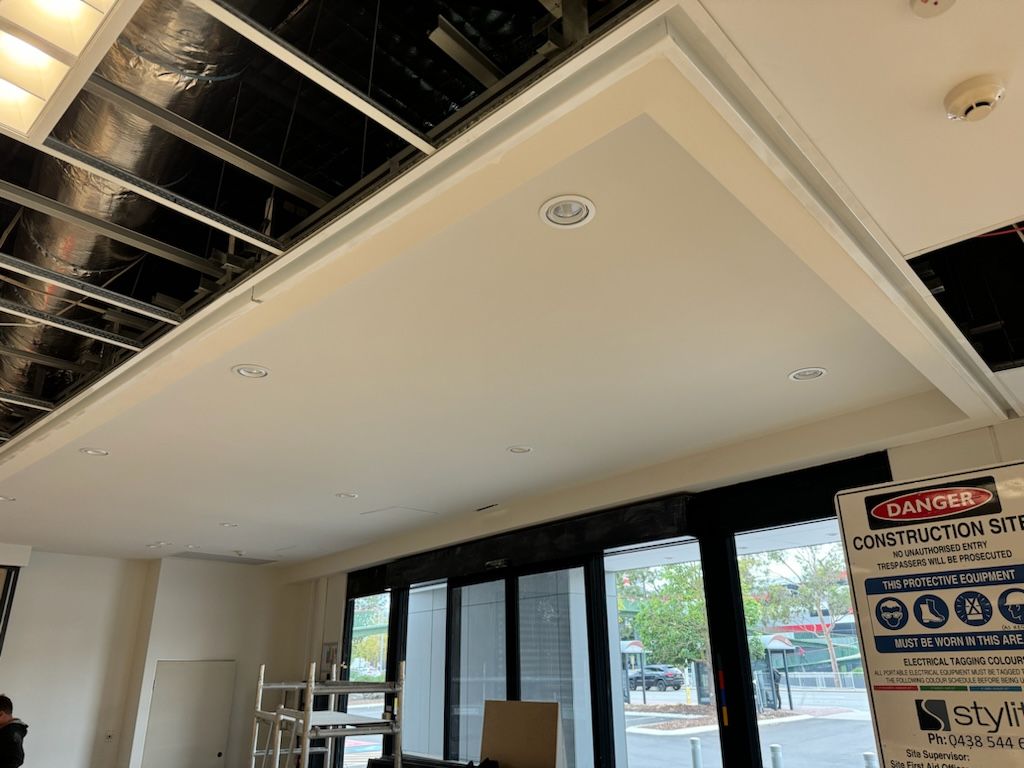 A room with a lot of windows and a ceiling that is being remodeled.