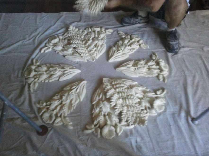 A person is sitting on a table with a bunch of sculptures on it