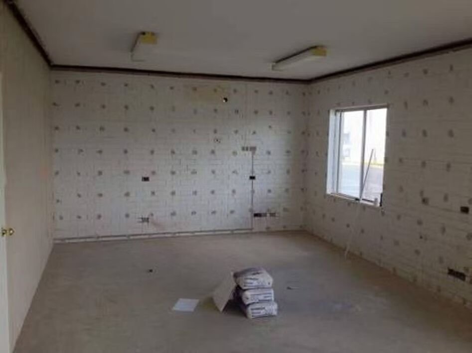 An empty room with white walls and a window.