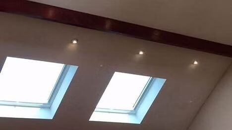 There are two skylights on the ceiling of a room.