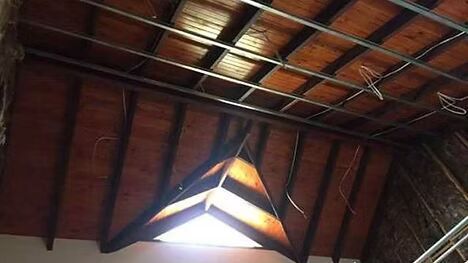 A wooden ceiling with a light hanging from it.