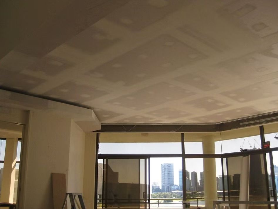 A room with a lot of windows and a ladder in it.