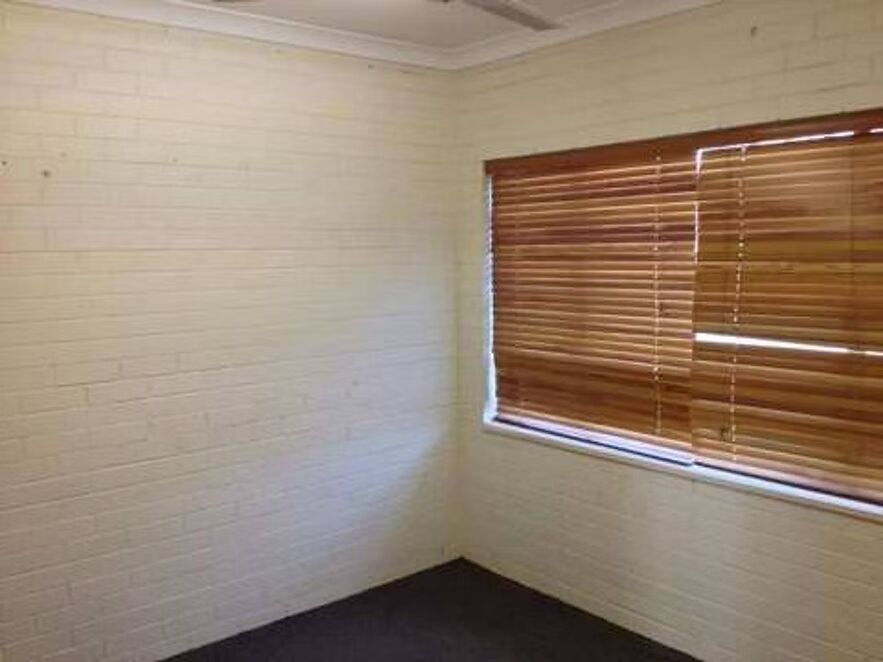 An empty room with a window and blinds.