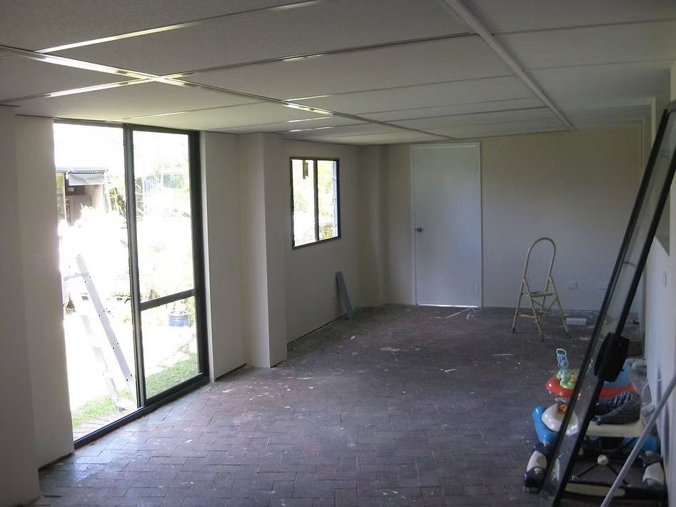 An empty room with a ladder and a window