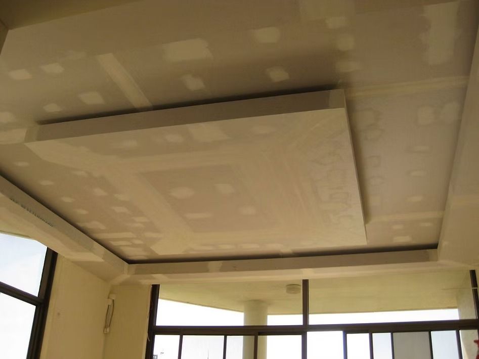 A room with a ceiling that is being built and a balcony.