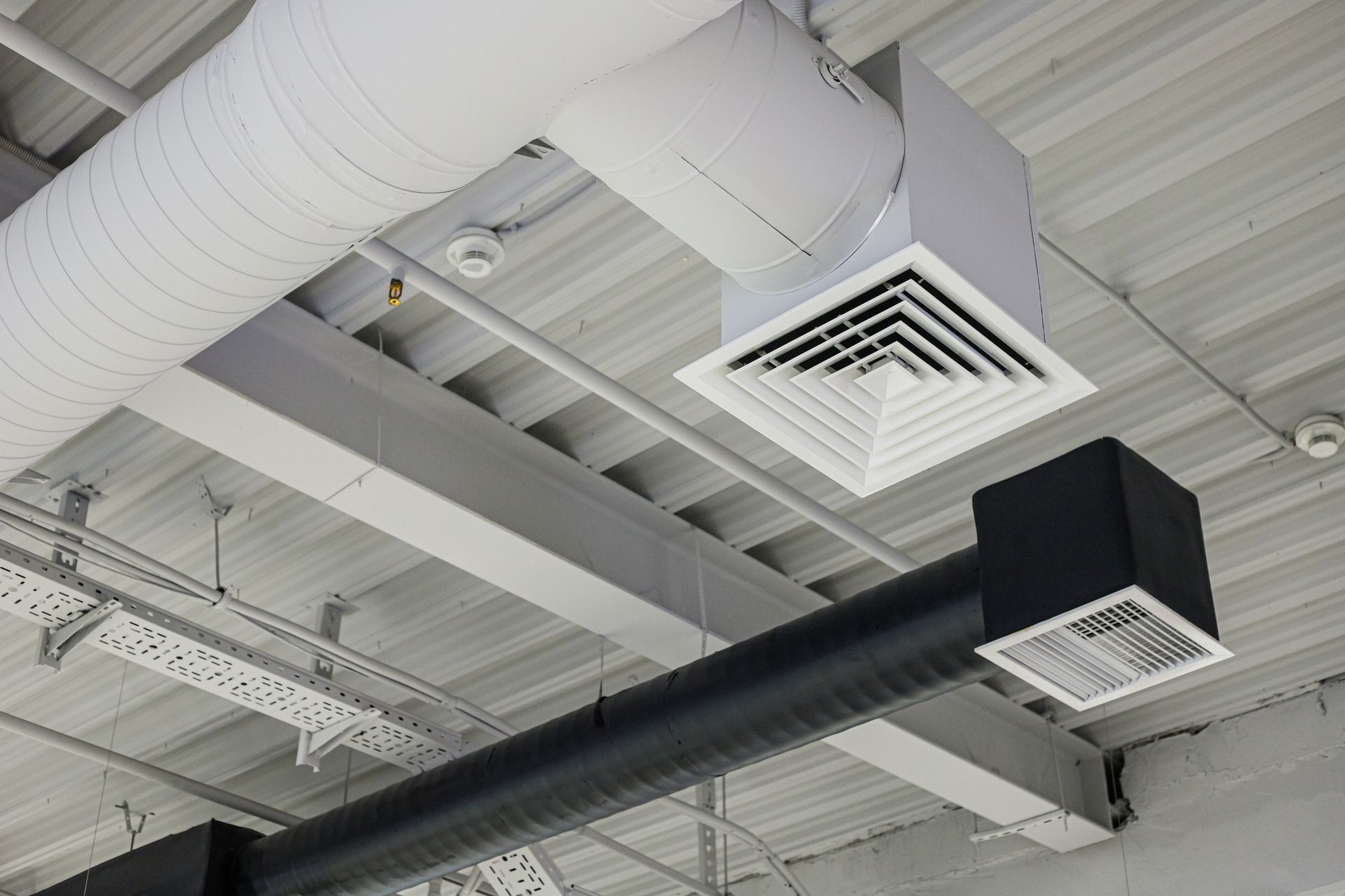 Two ventilation duct systems with grilles under the ceiling in a commercial building. Two ventilation duct systems with grilles under the ceiling in a commercial building.