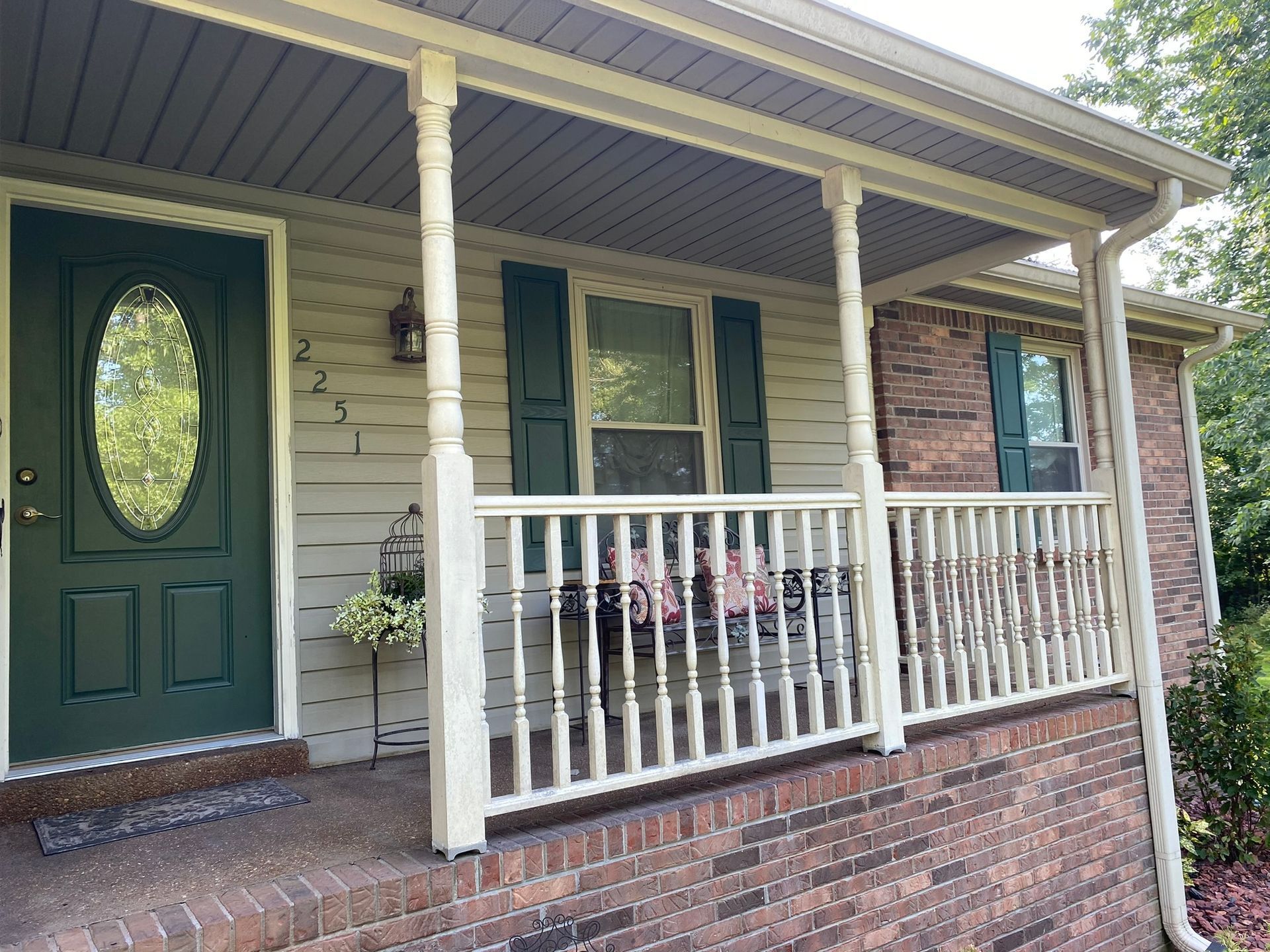 A house with a porch and a green door