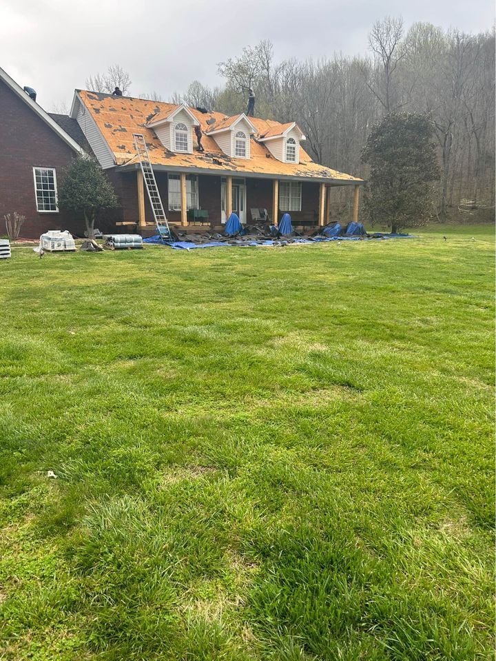 A house is being remodeled in a large grassy field.