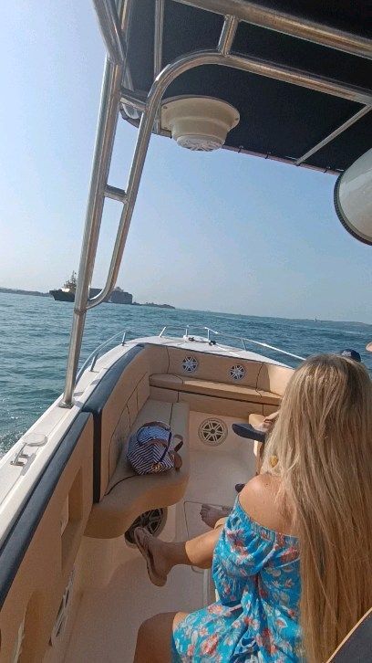 Una mujer está sentada en la parte trasera de un barco en el océano.