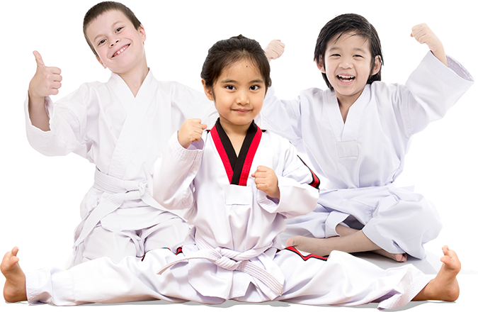 Three children in karate uniforms are sitting on the floor and giving a thumbs up.