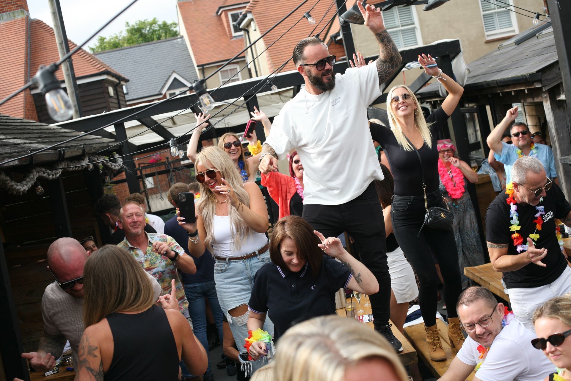 A man is jumping in the air in front of a crowd of people at a party.