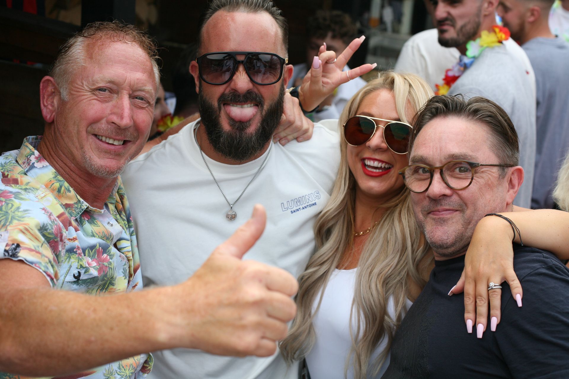 A group of people are posing for a picture and one of them is giving a thumbs up.
