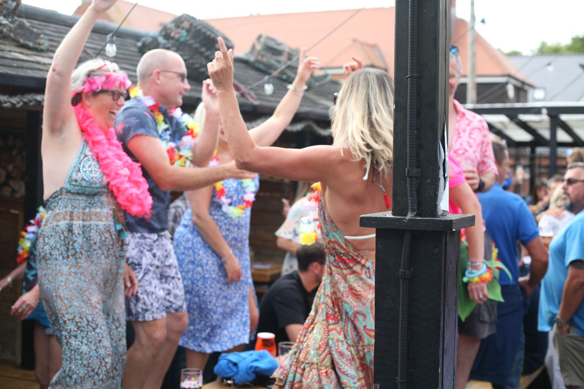 A group of people are dancing in front of a pole.