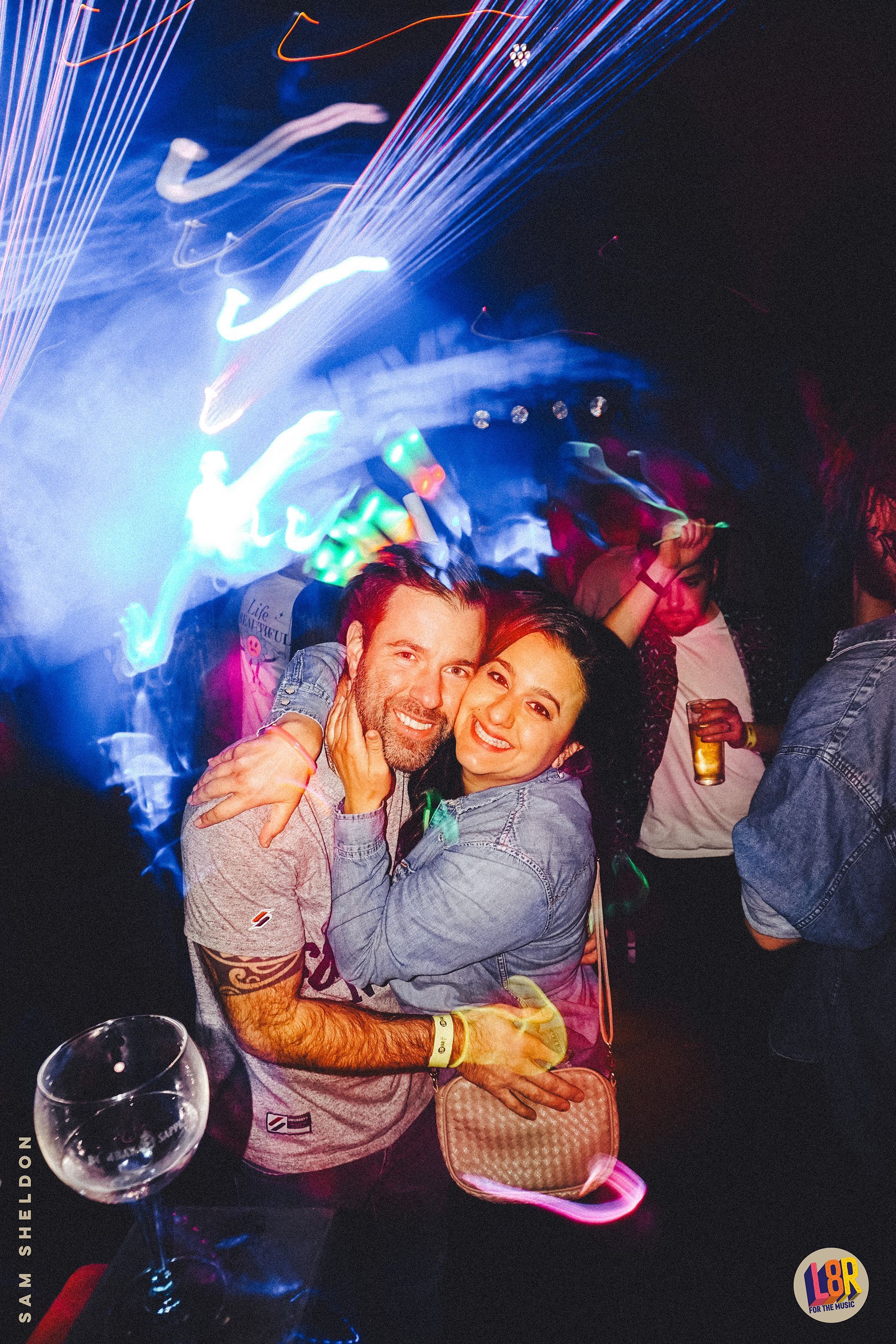 A man and a woman are posing for a picture at a party.