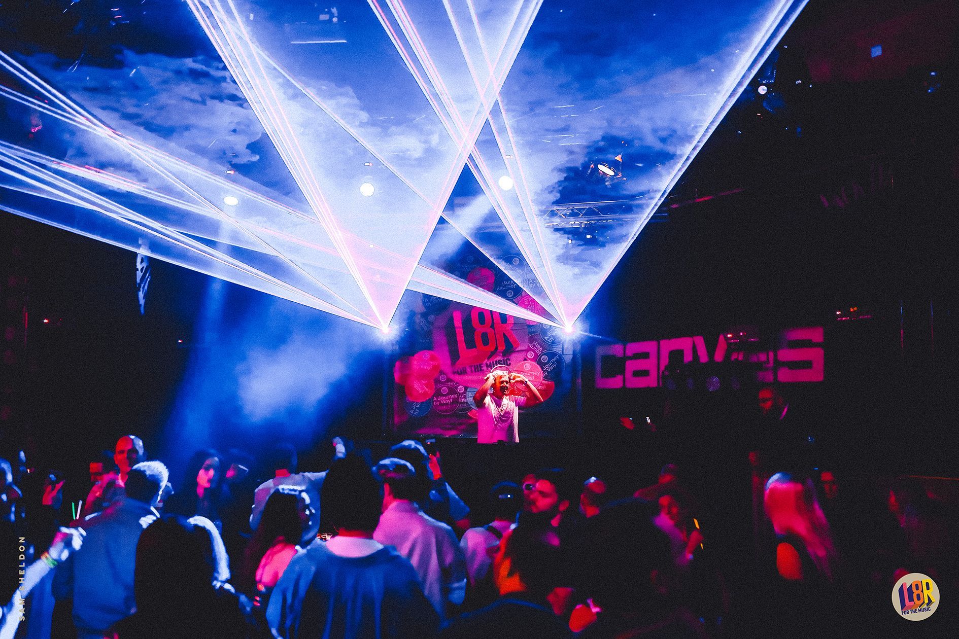 A crowd of people are gathered in front of a stage that says canvas