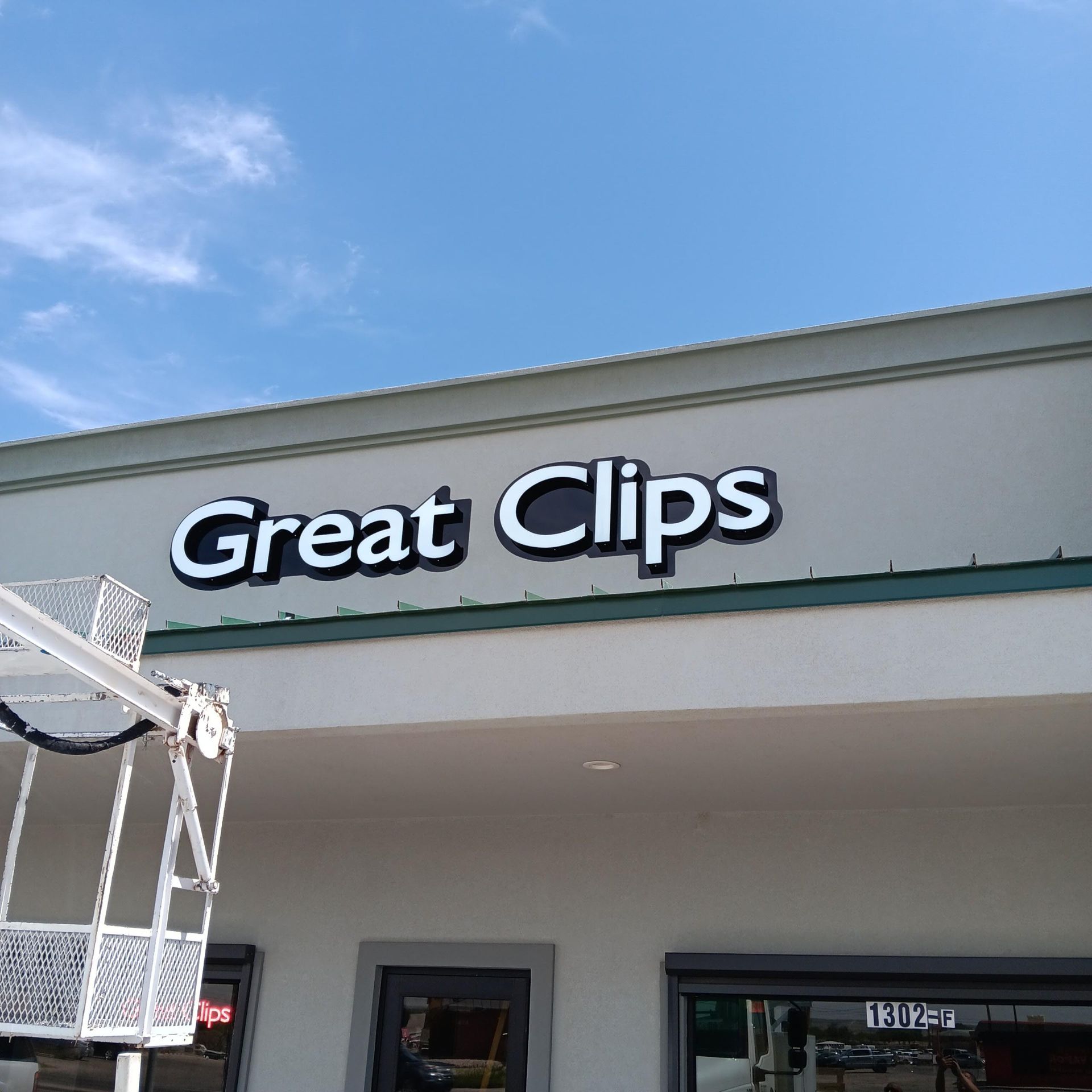 A white building with a sign that says great clips