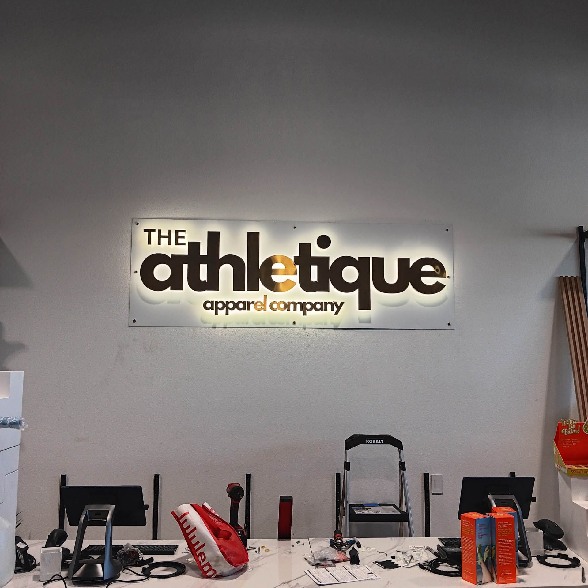 A sign for the athletic apparel company hangs above a desk