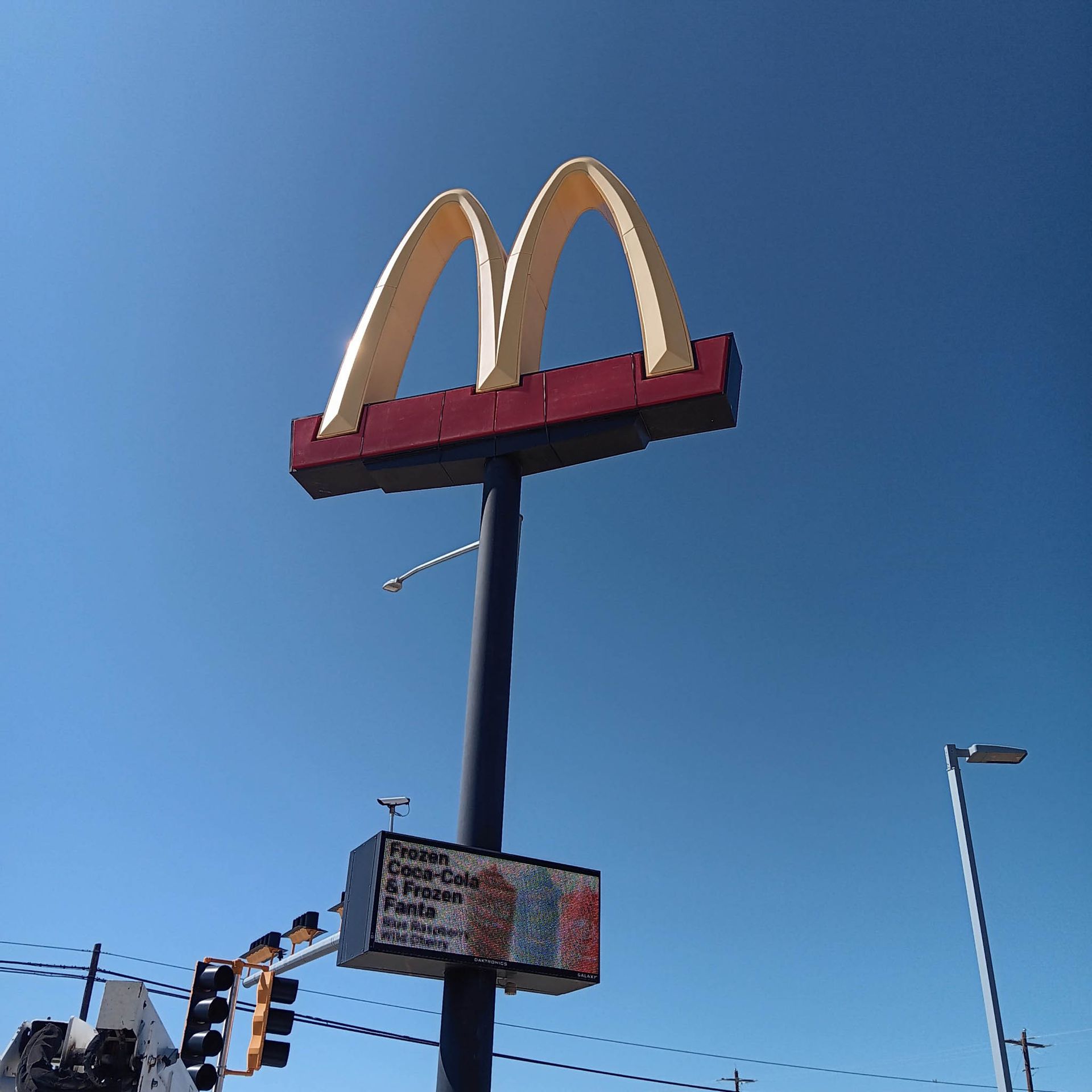 A large mcdonald 's sign against a blue sky