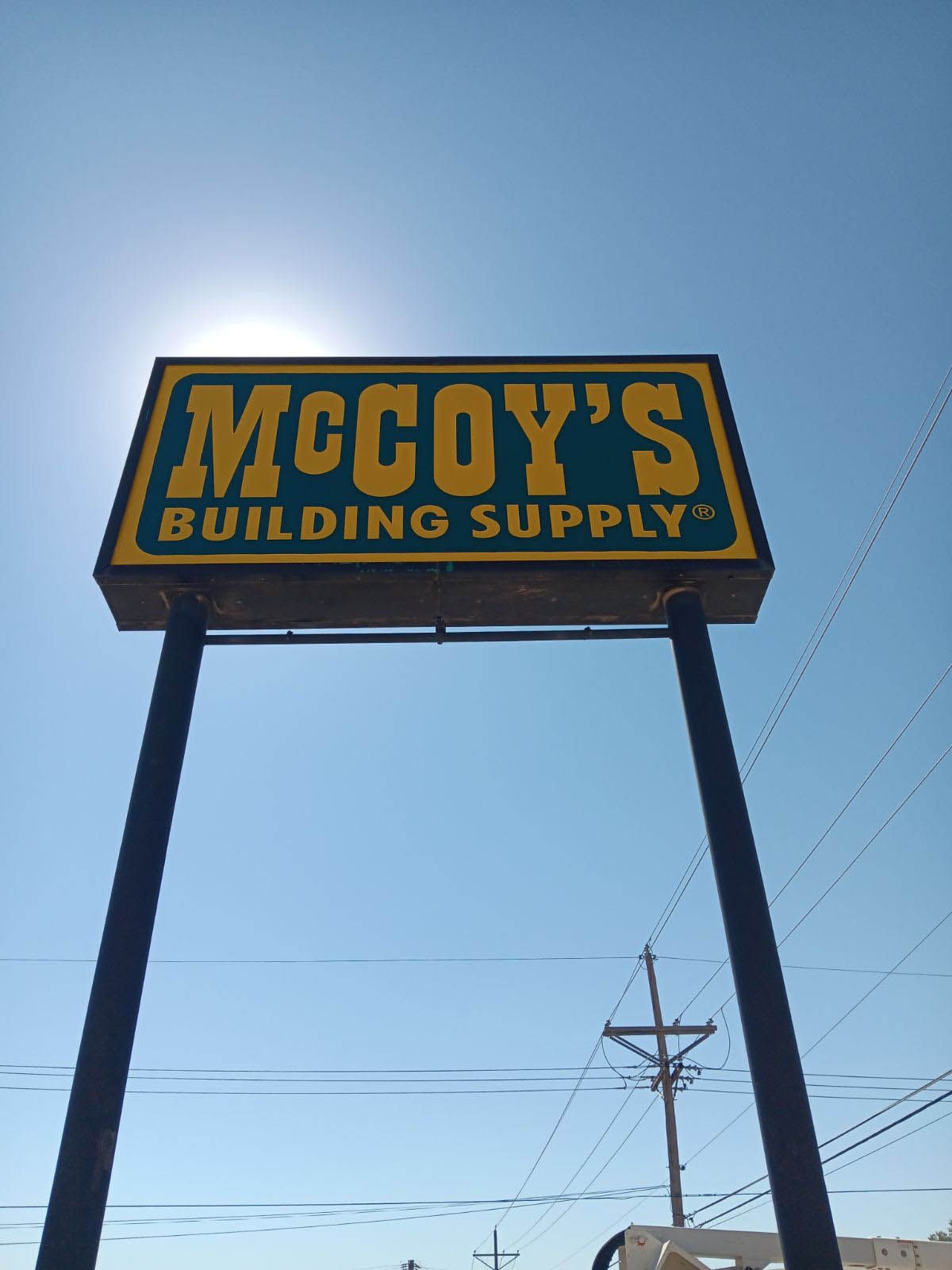 A mccoy 's building supply sign against a blue sky