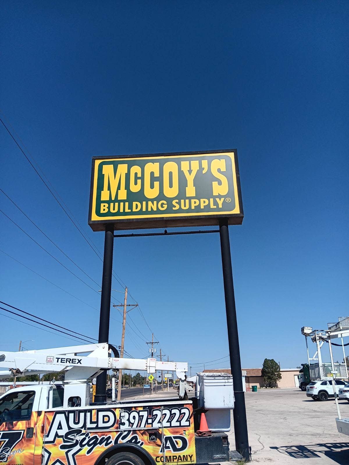 A large yellow sign for mccoy 's building supply