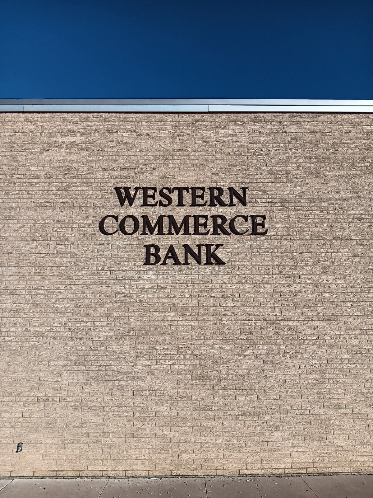 A brick wall with the words western commerce bank painted on it