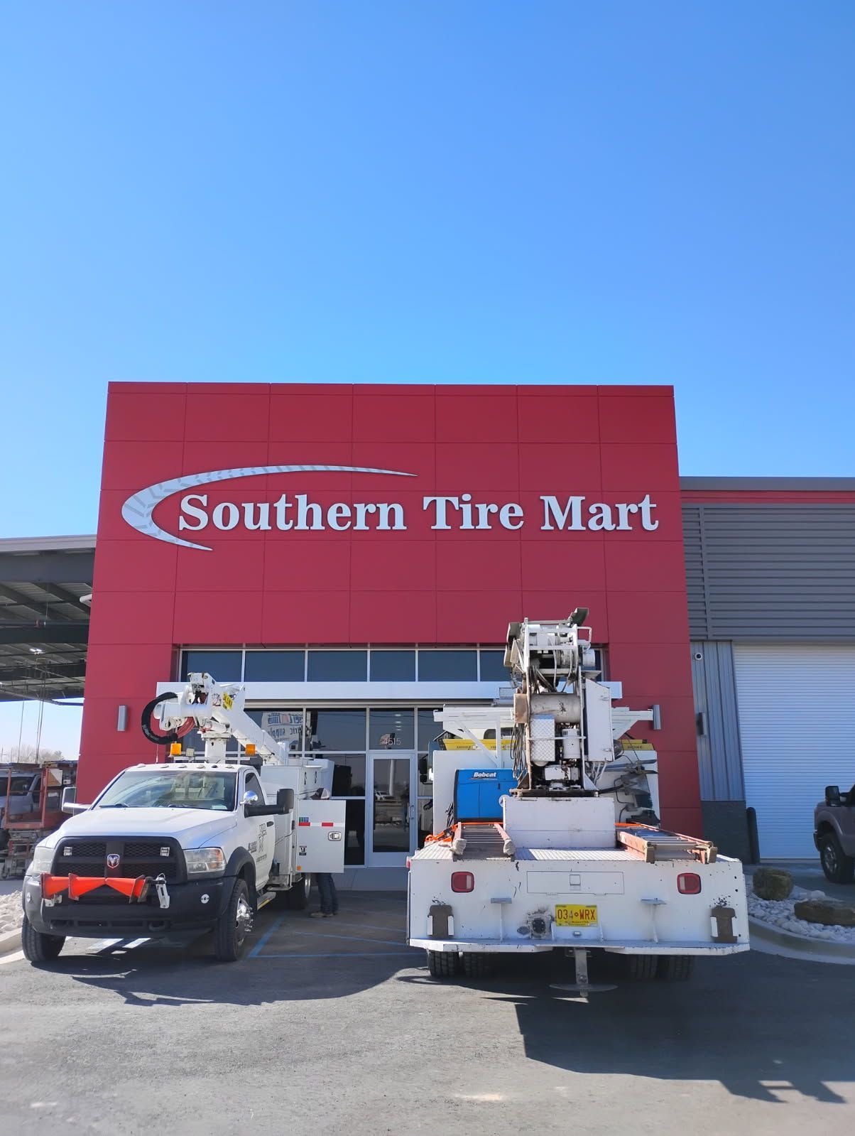 Two trucks are parked in front of a southern tire mart