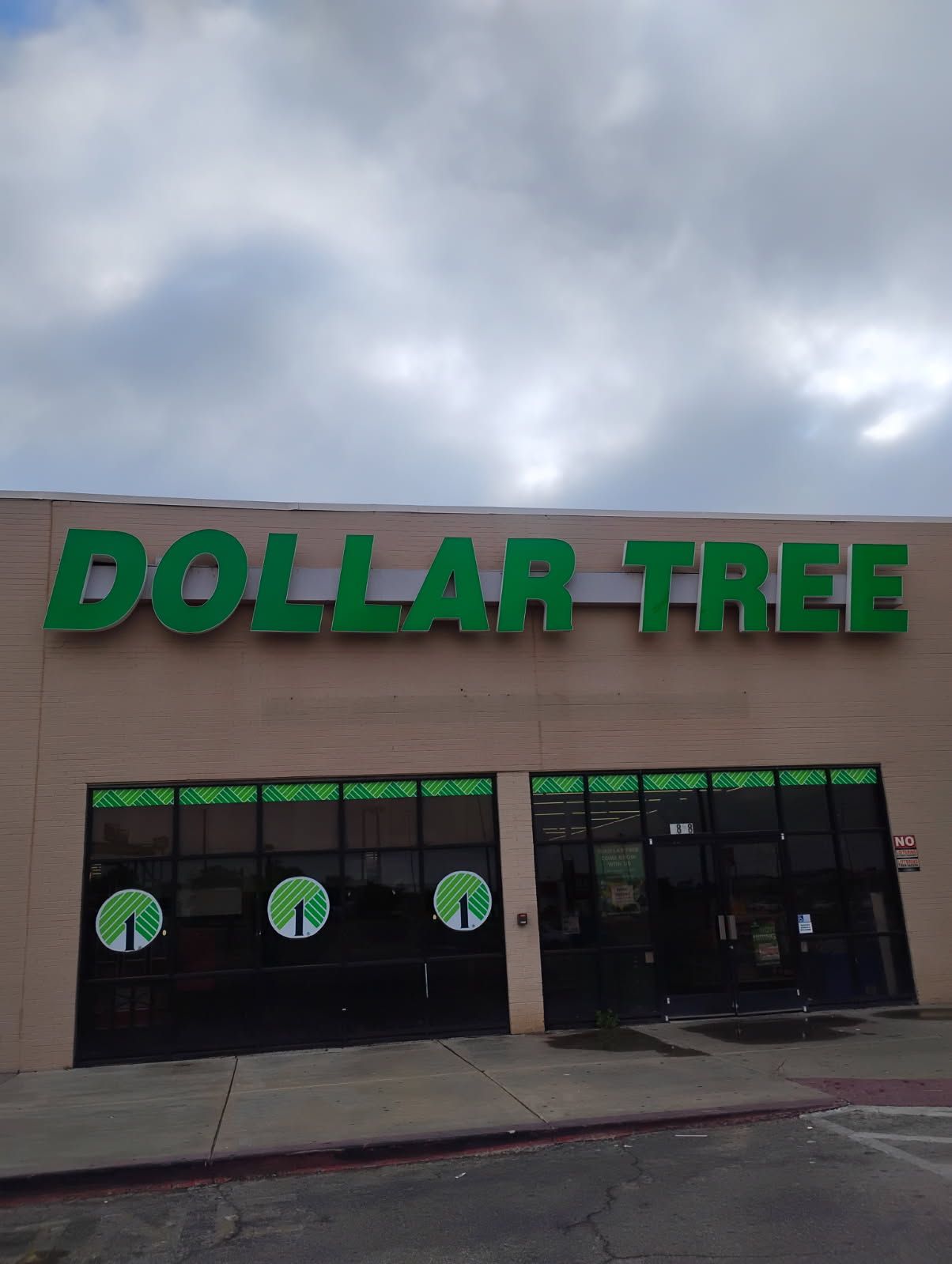The front of a dollar tree store with a cloudy sky in the background.