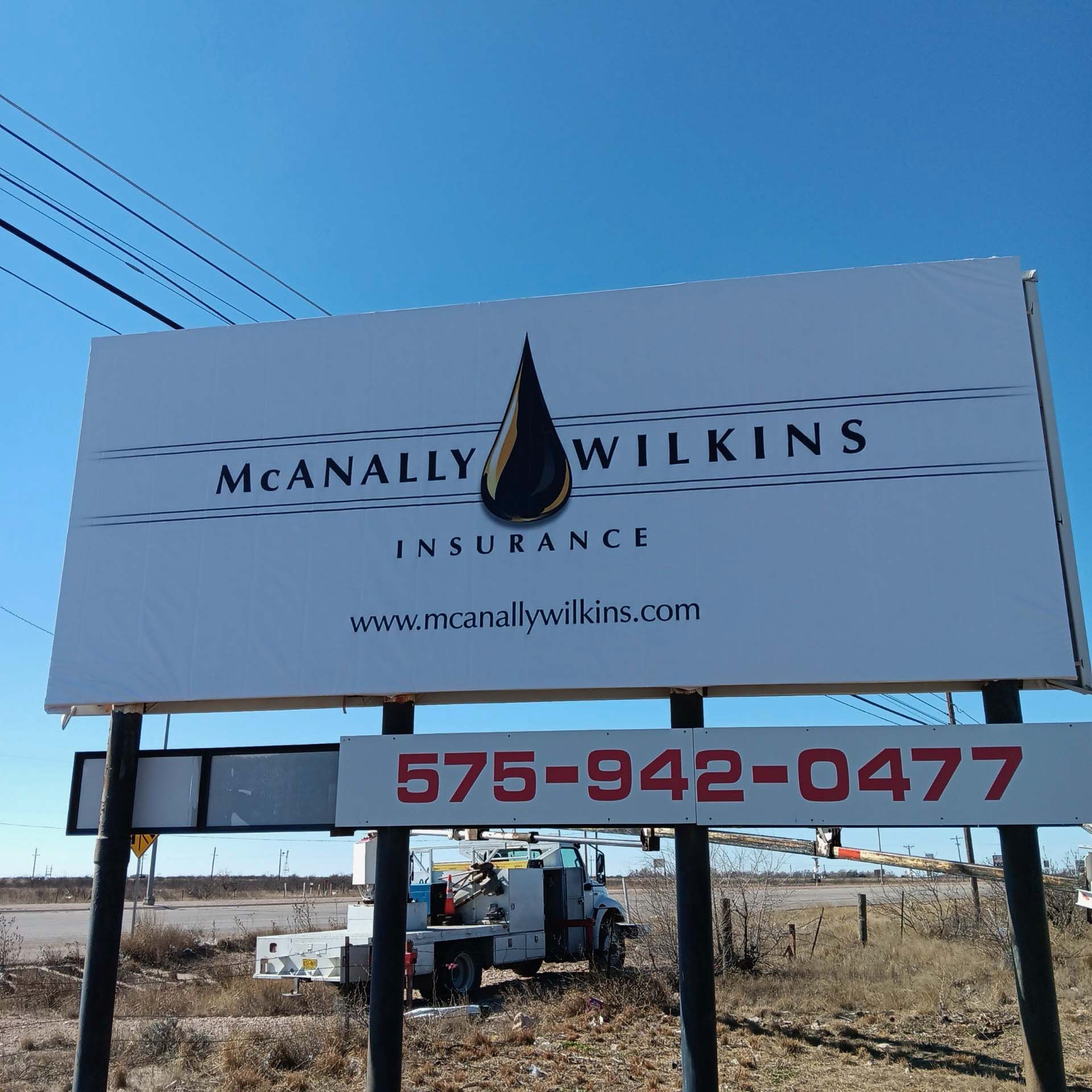 A billboard for meanally wilkins insurance with a phone number