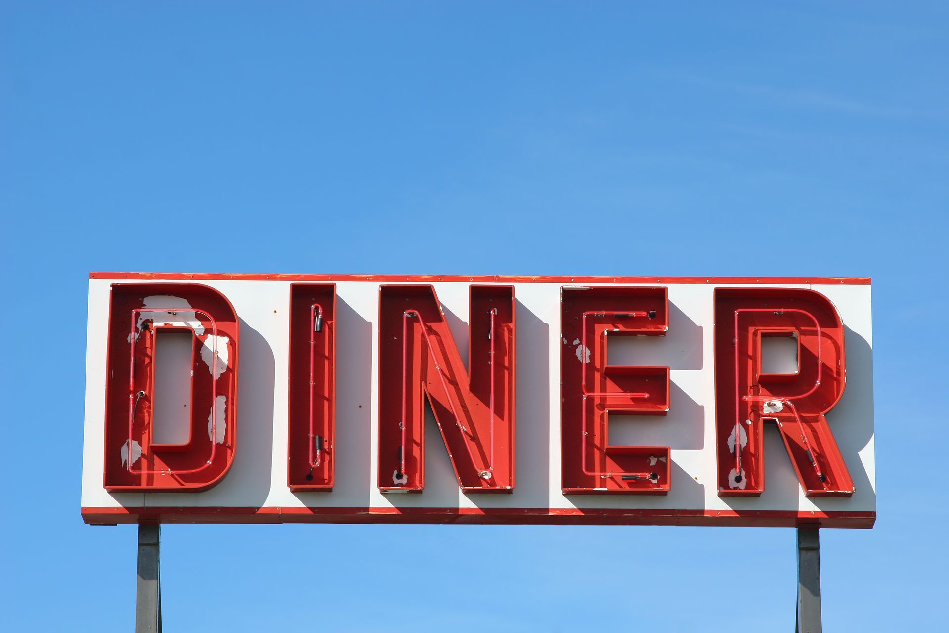 A diner sign with a blue sky in the background