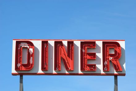 A diner sign with a blue sky in the background
