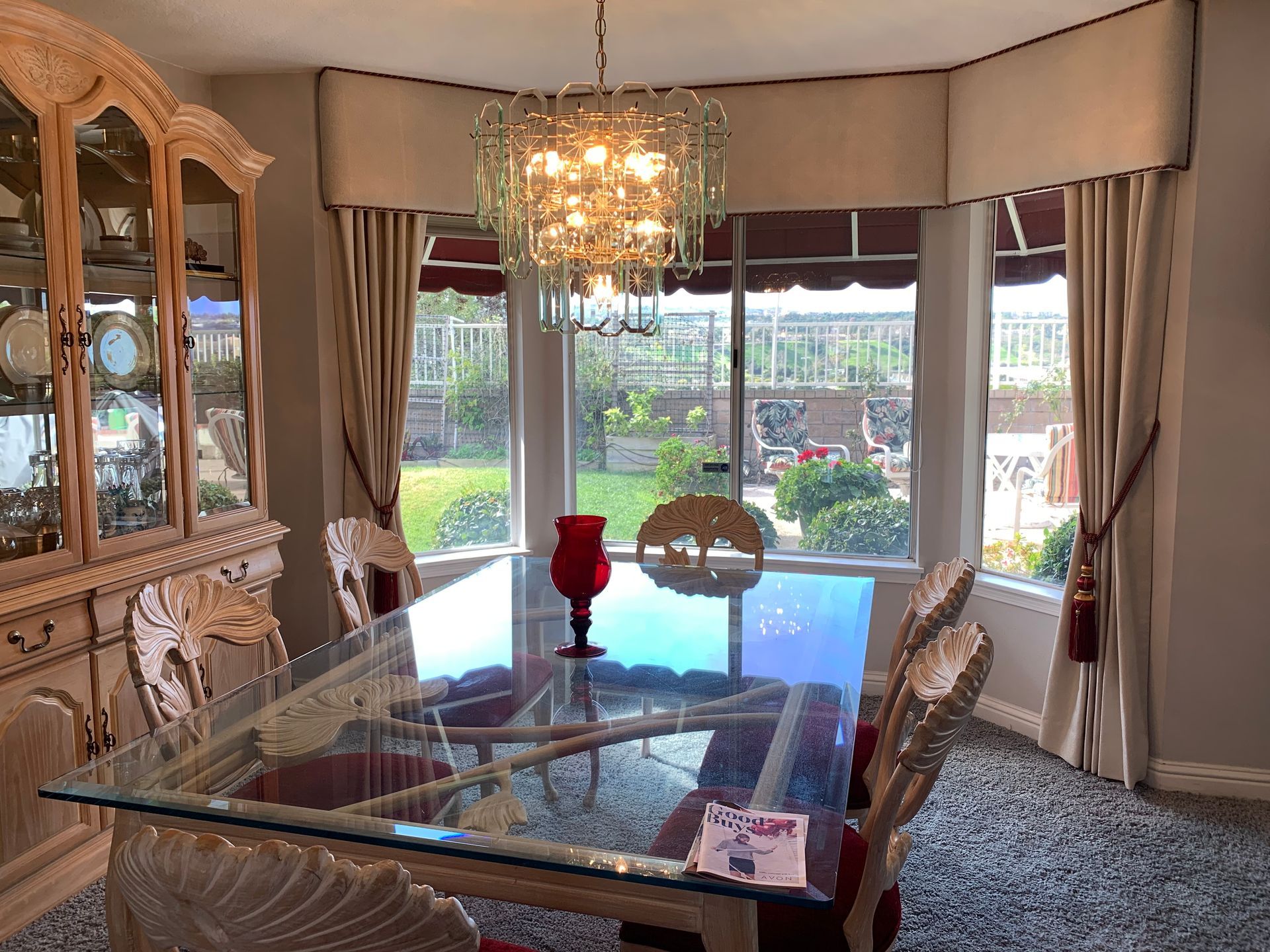 A dining room with a glass table and chairs and a chandelier.