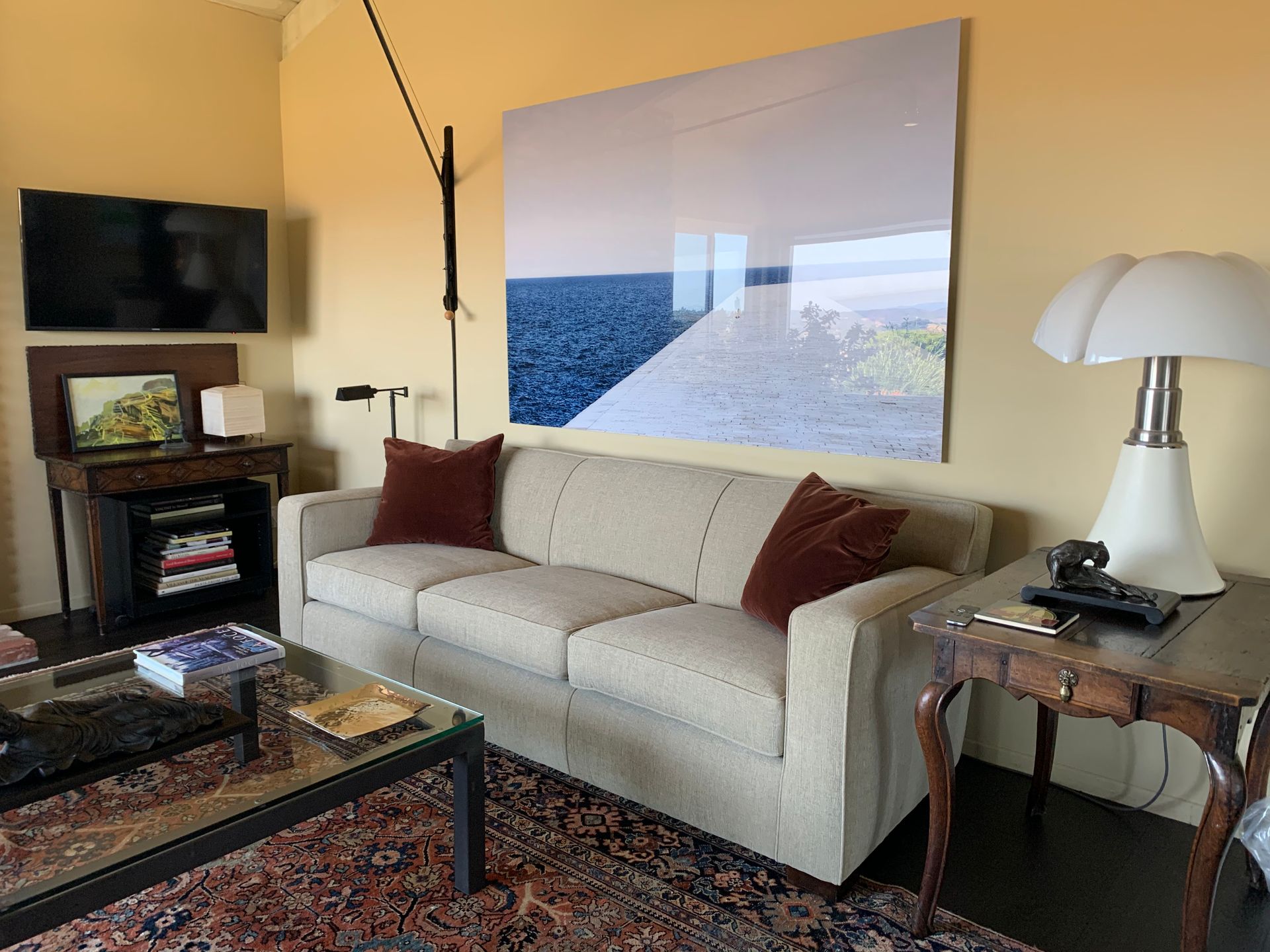 A living room with a couch , table , lamp and television.