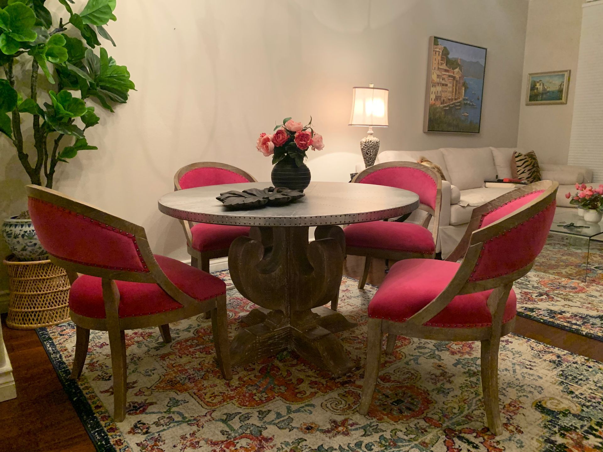 A living room with a round table and pink chairs