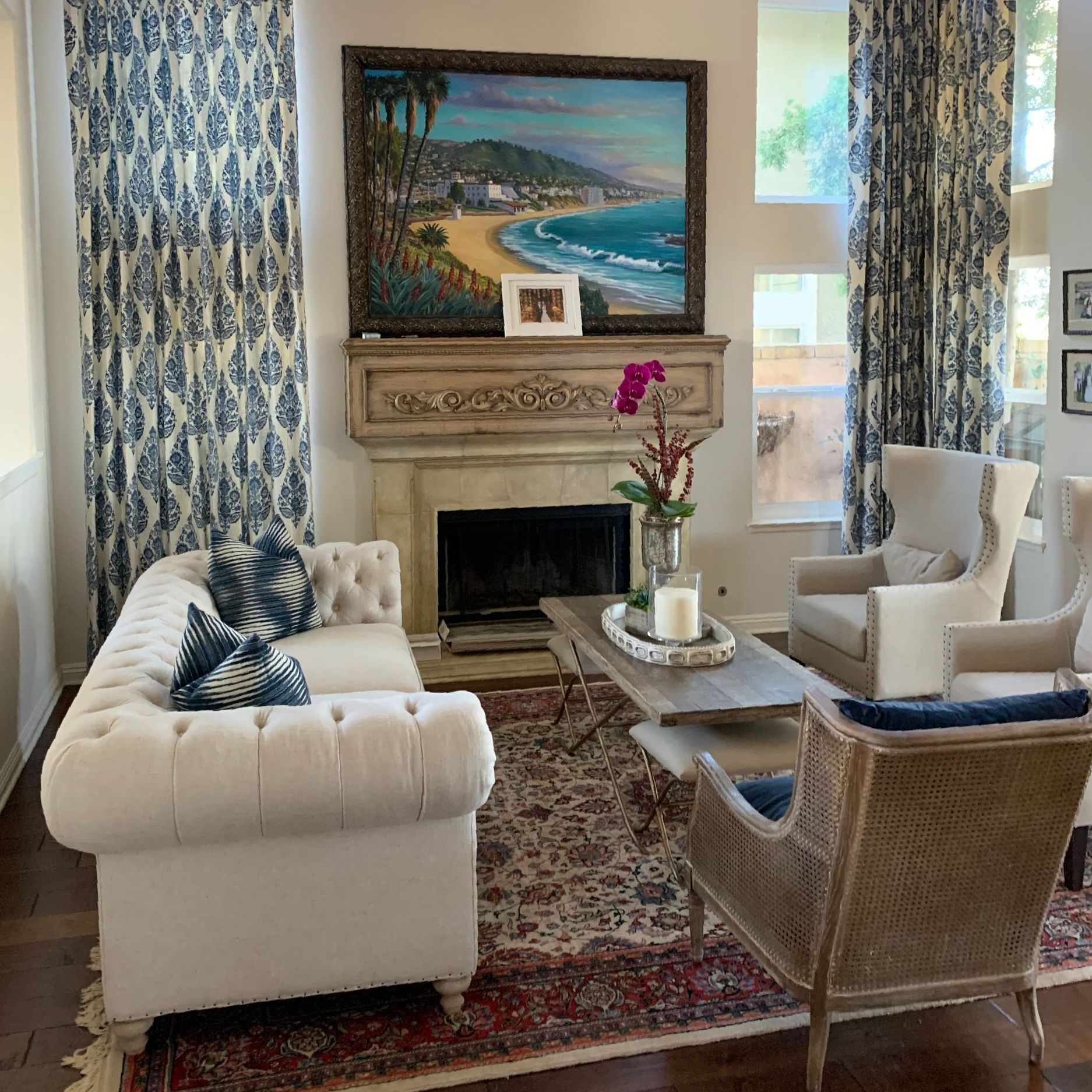 A living room with a couch , chairs , coffee table and fireplace.