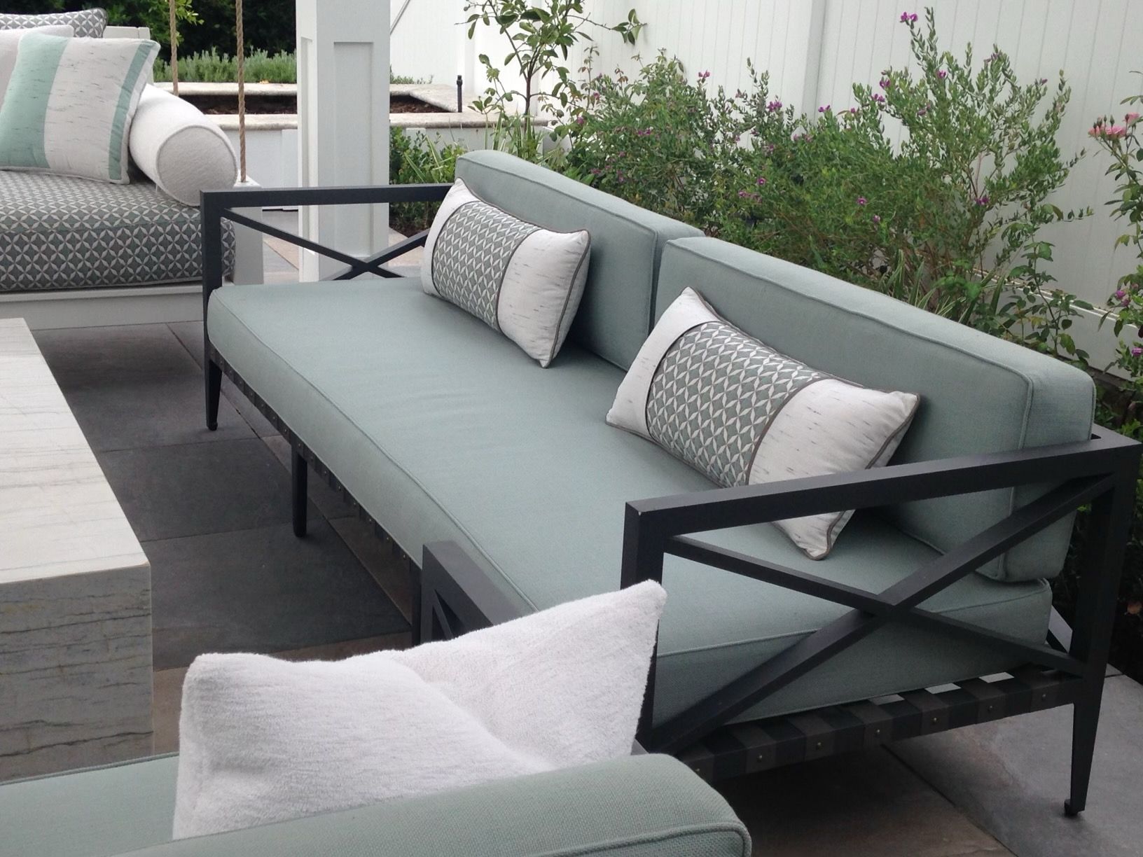 A couch with pillows on it sits on a patio