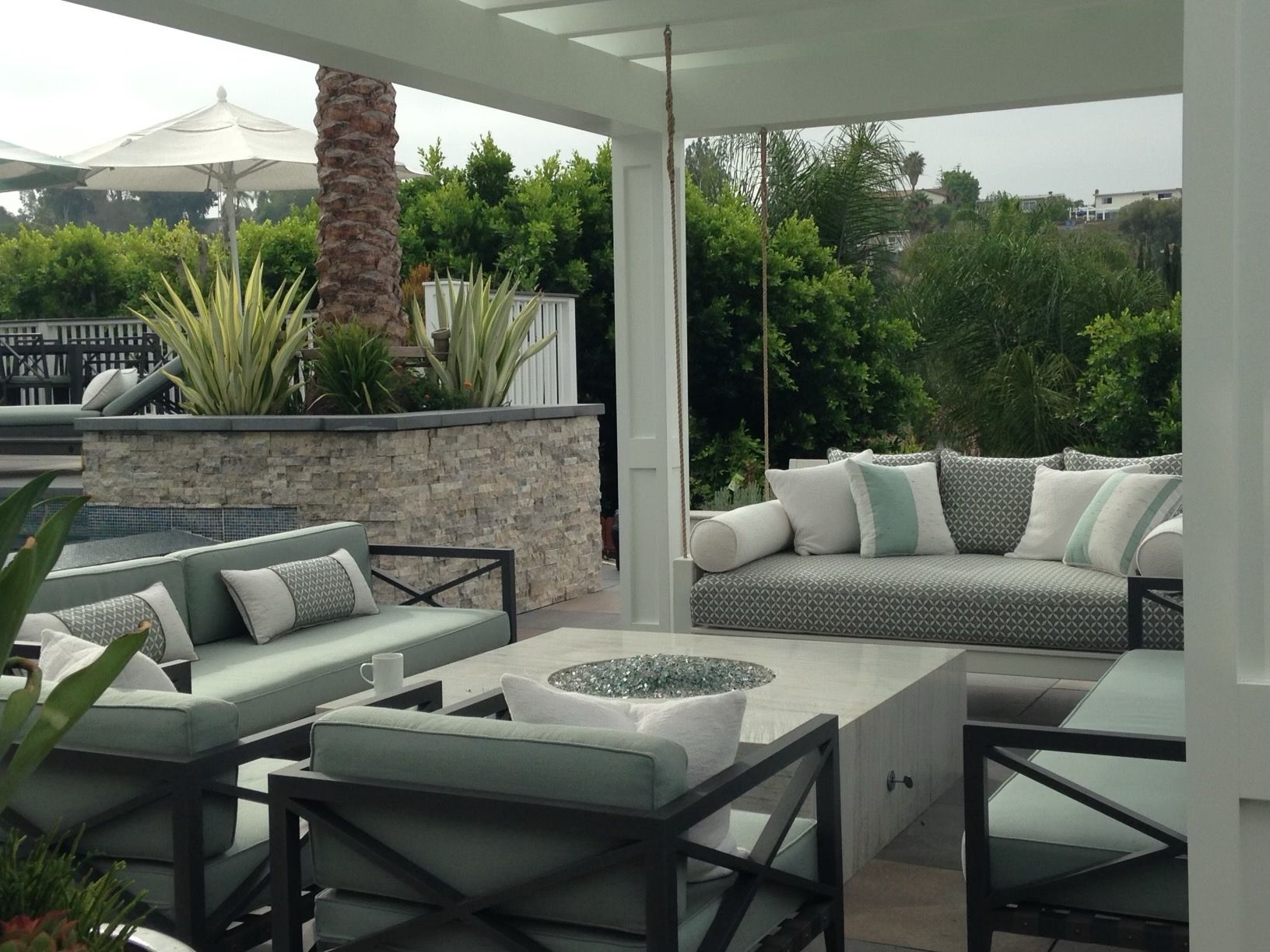 A patio with a couch and chairs and a fire pit