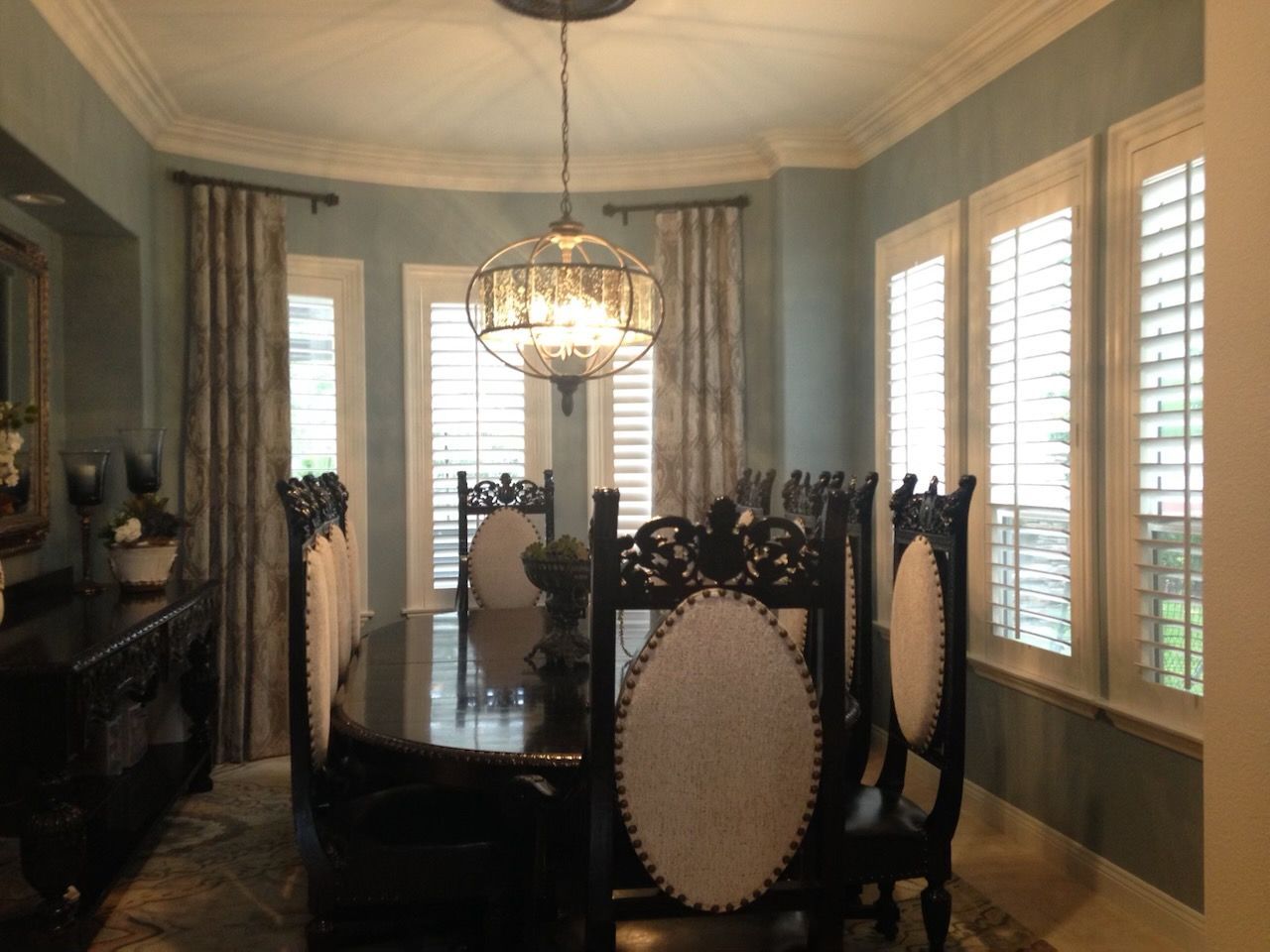 A dining room with a table and chairs and a chandelier