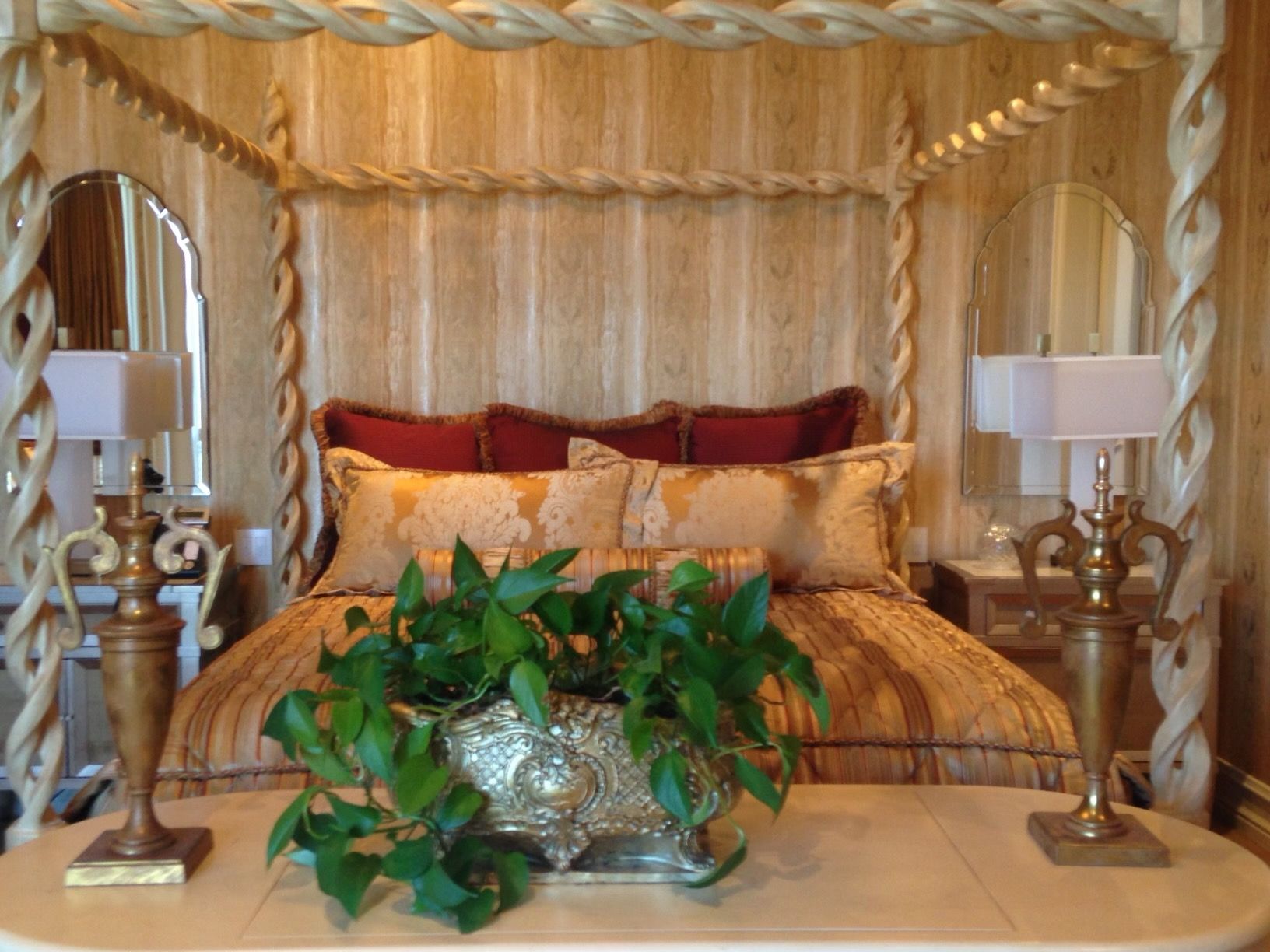 A bedroom with a canopy bed and two lamps
